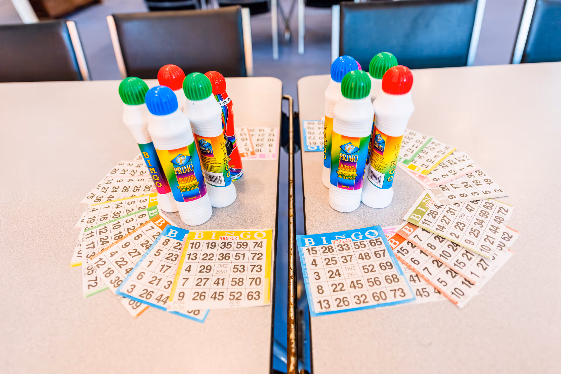 Bingo cards and markers arranged on a table in a senior living facility activity area.