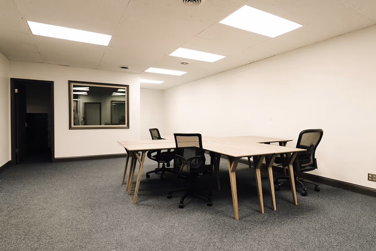 Plain conference room in a senior living facility with tables, chairs, and fluorescent ceiling lights.