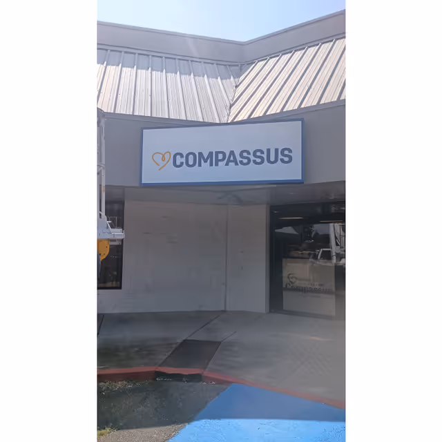 Exterior view of a Compassus facility with signage above the entrance.