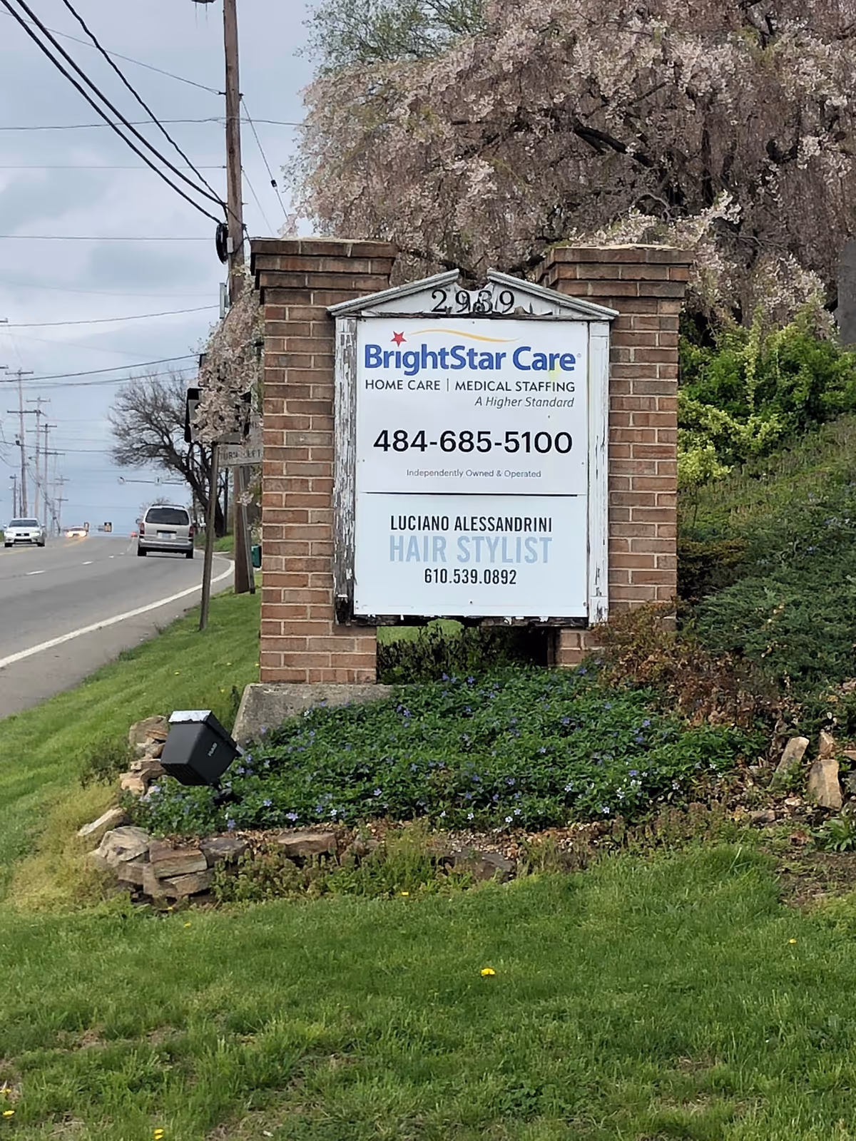 Street-side brick sign for BrightStar Care with landscaped area along the road.