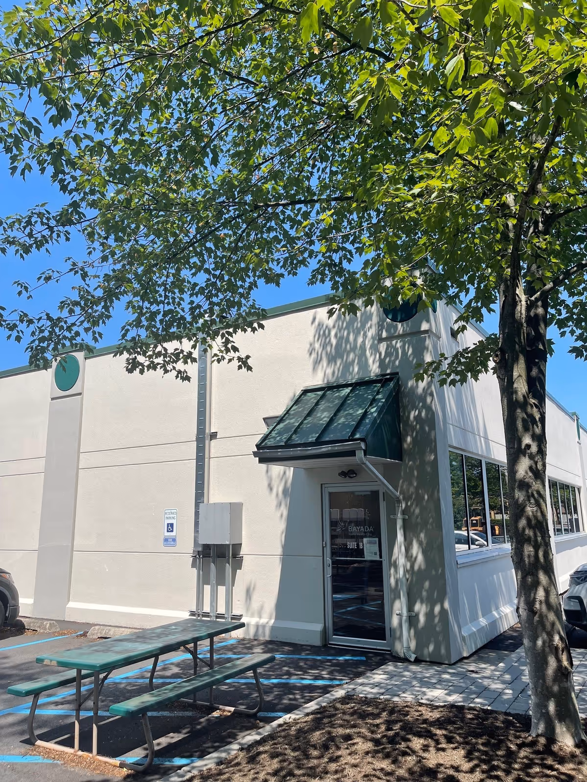 Exterior view of BAYADA Adult Nursing facility with entrance awning and a green picnic table outside.