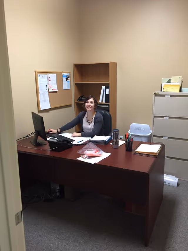 Office at Comfort Keepers Home Care with a smiling staff member at desk.
