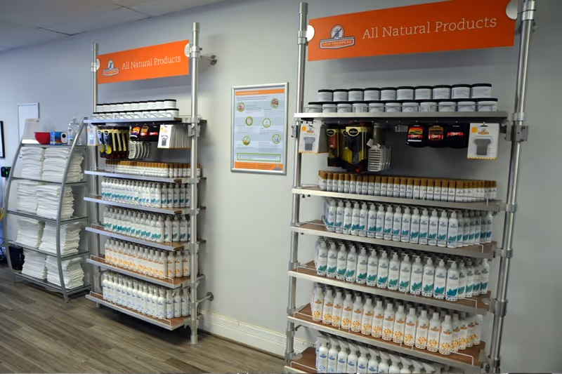Interior display area with metal shelves stocked with all-natural lice removal products and bottles.