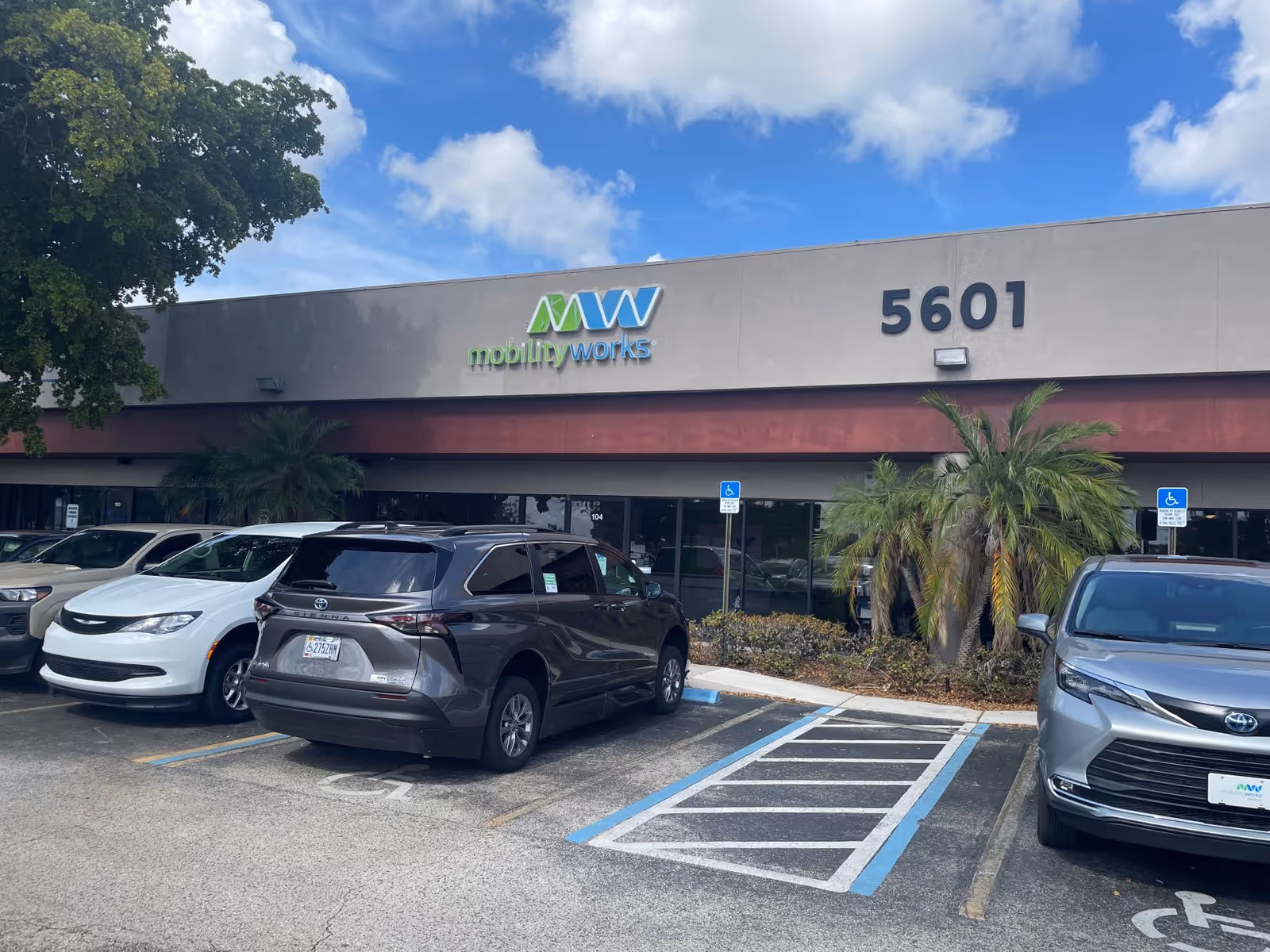Front view of MobilityWorks building with parked cars and handicap signage.