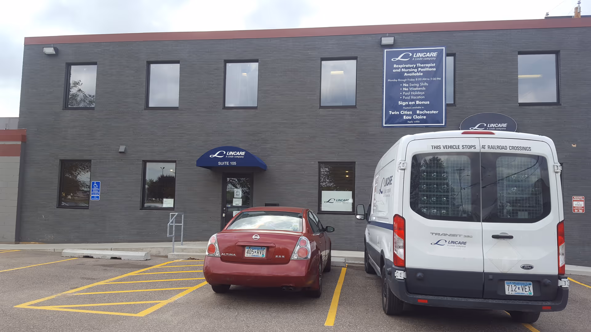 Exterior of a Lincare building with a blue awning and parked car and van.