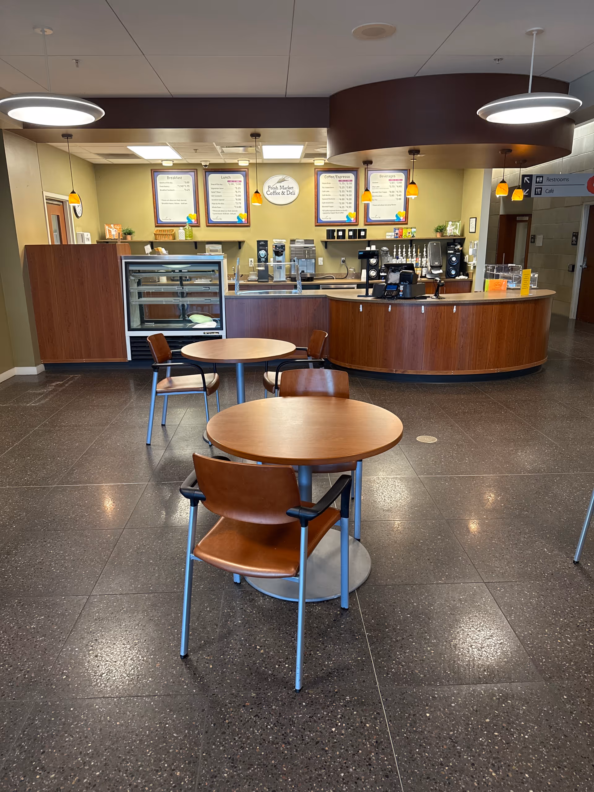 Interior cafe-style dining area with tables, chairs, and a curved service counter