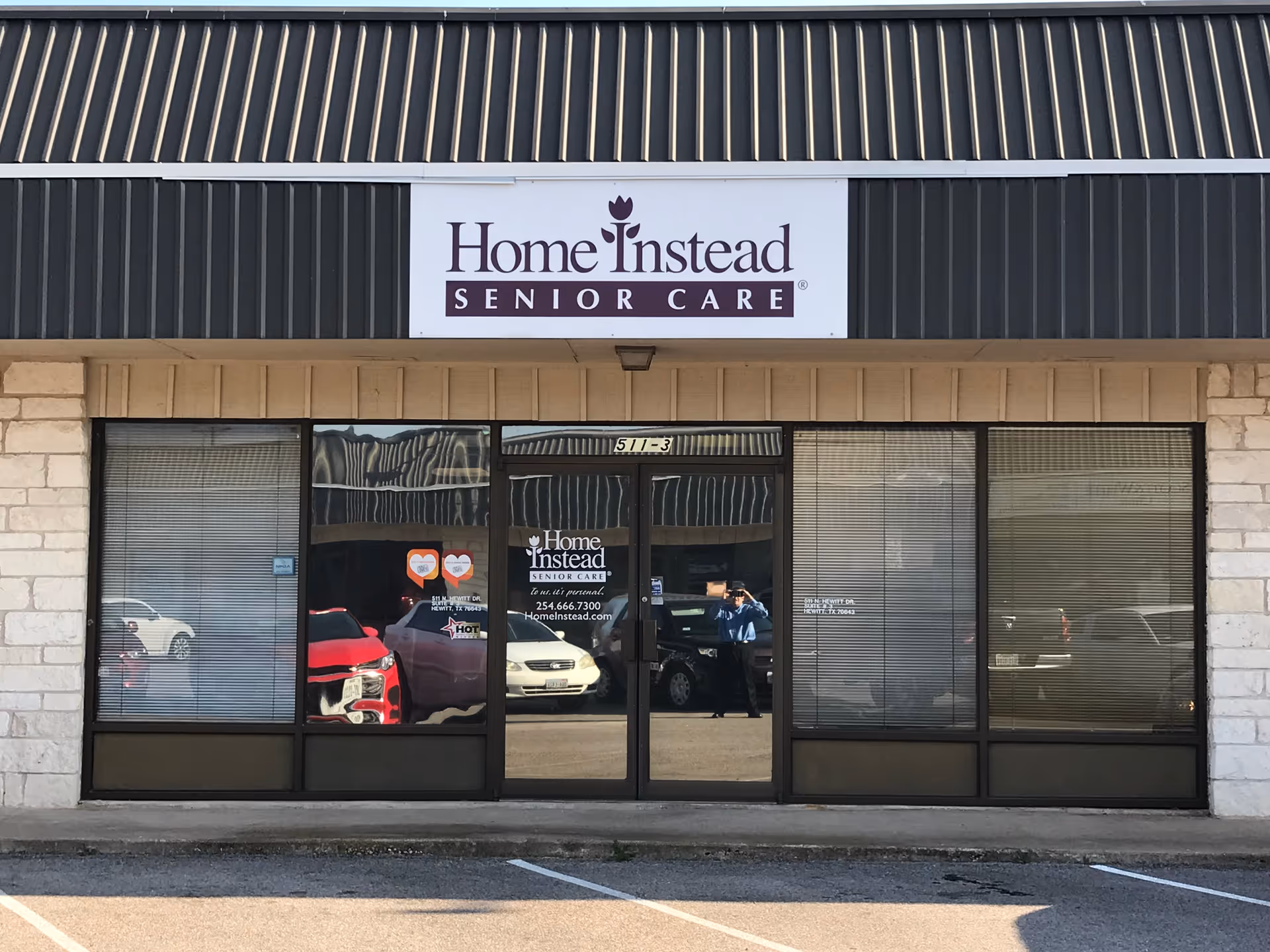 Exterior view of a Home Instead Senior Care storefront with glass doors.