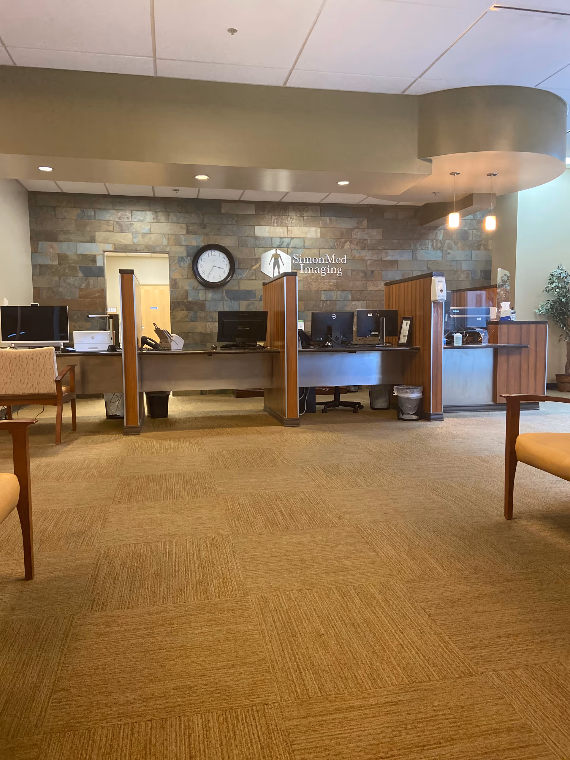 Front desk area with computer stations and SimonMed Imaging sign in Almighty Homecare Services.