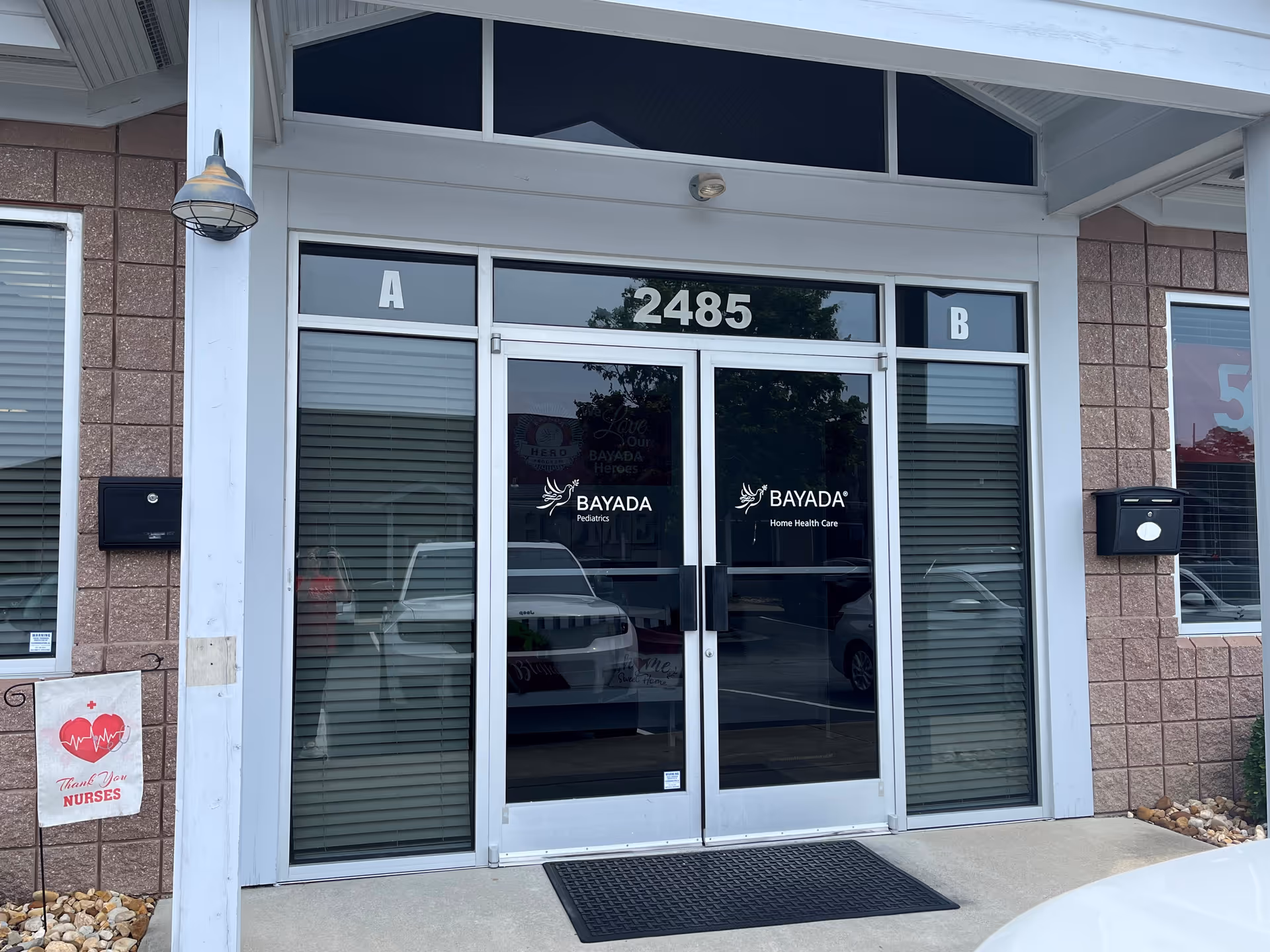 Glass double doors labeled BAYADA Pediatrics at a building front entrance.