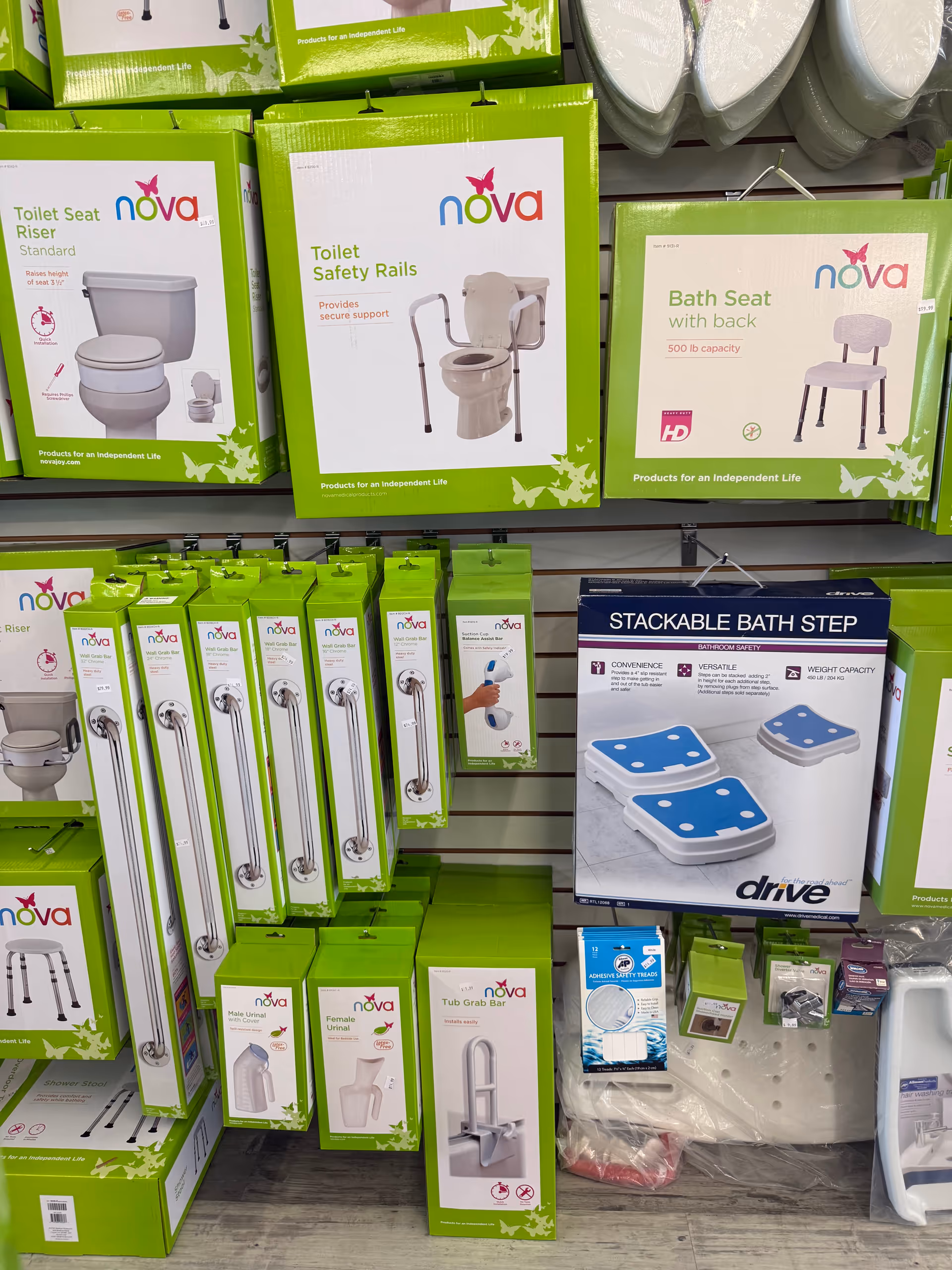 Display of green Nova bathroom aids and rails on shelves inside Gallant Medical Supply