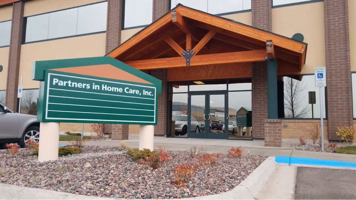 Exterior view of a building entrance with a green Partners in Home Care, Inc. sign.