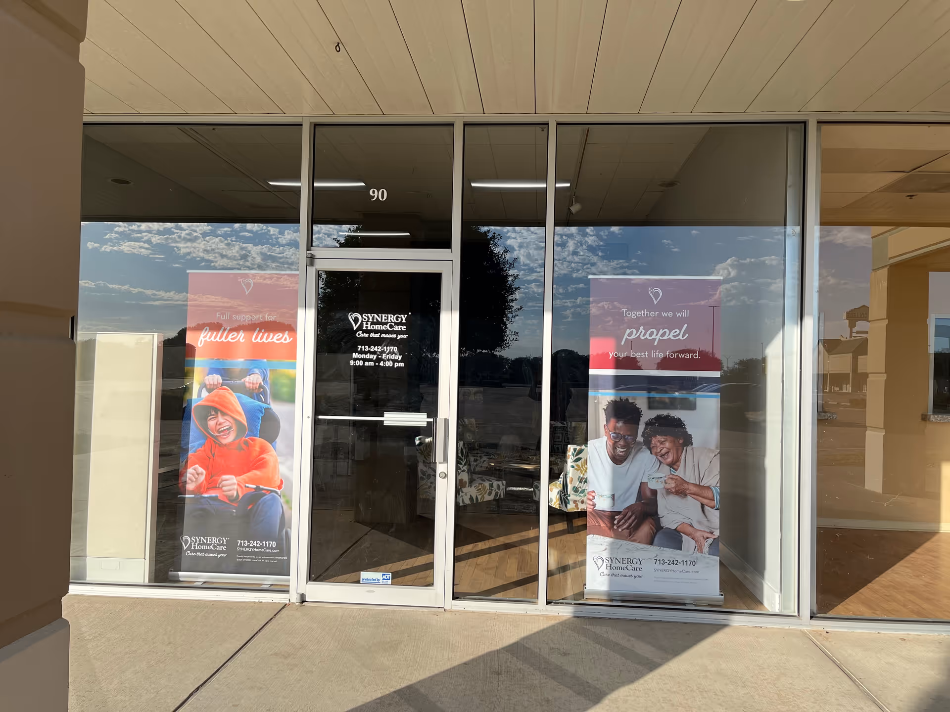 Glass-door entrance of SYNERGY HomeCare with banners in front of the facility.