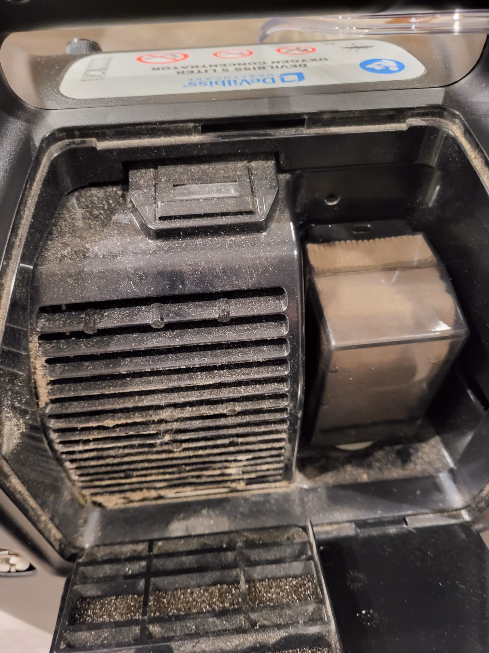 Close-up of a dusty interior machine with vent slats inside a facility.