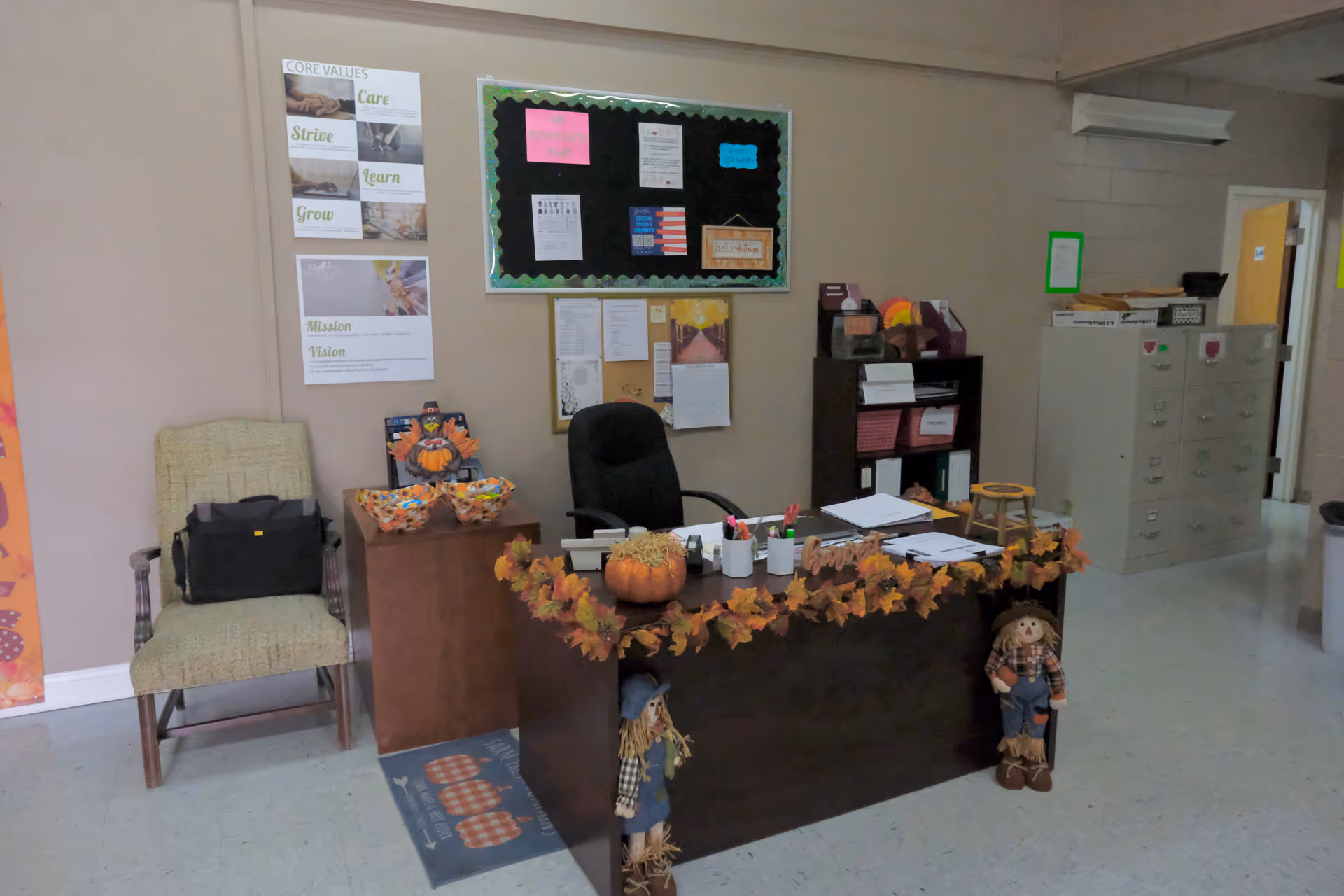 Reception desk inside a senior living facility decorated with pumpkins and autumn garlands.