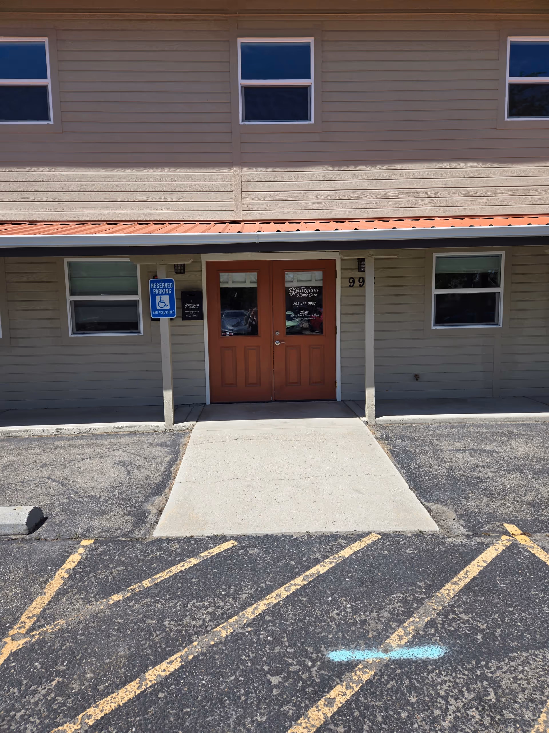 Exterior view of Allegiant Home Care building entrance with orange doors and handicap parking sign