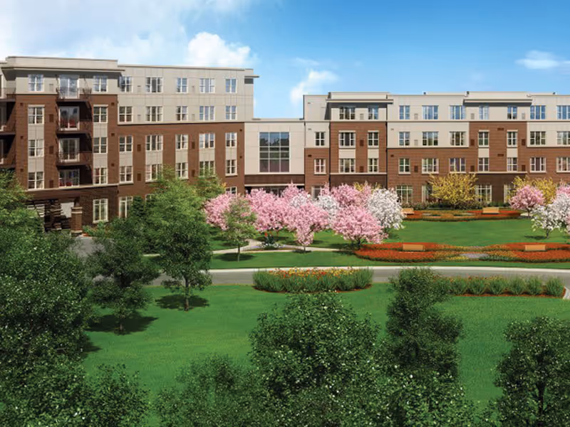 Exterior view of a modern senior living campus with landscaped lawns and blooming trees.
