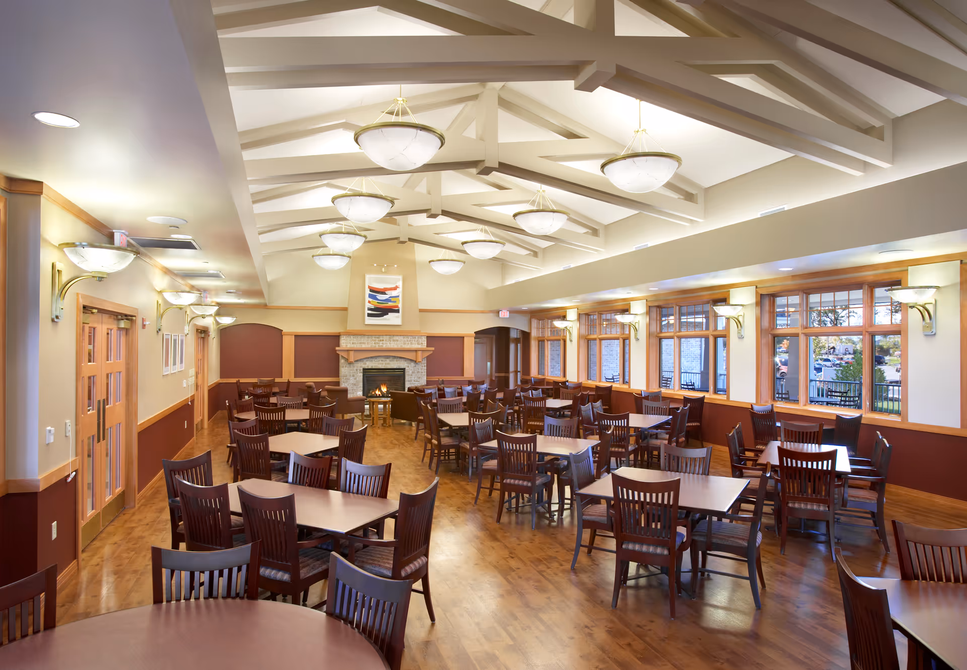 Bright dining hall in a senior living facility with many tables and chairs.