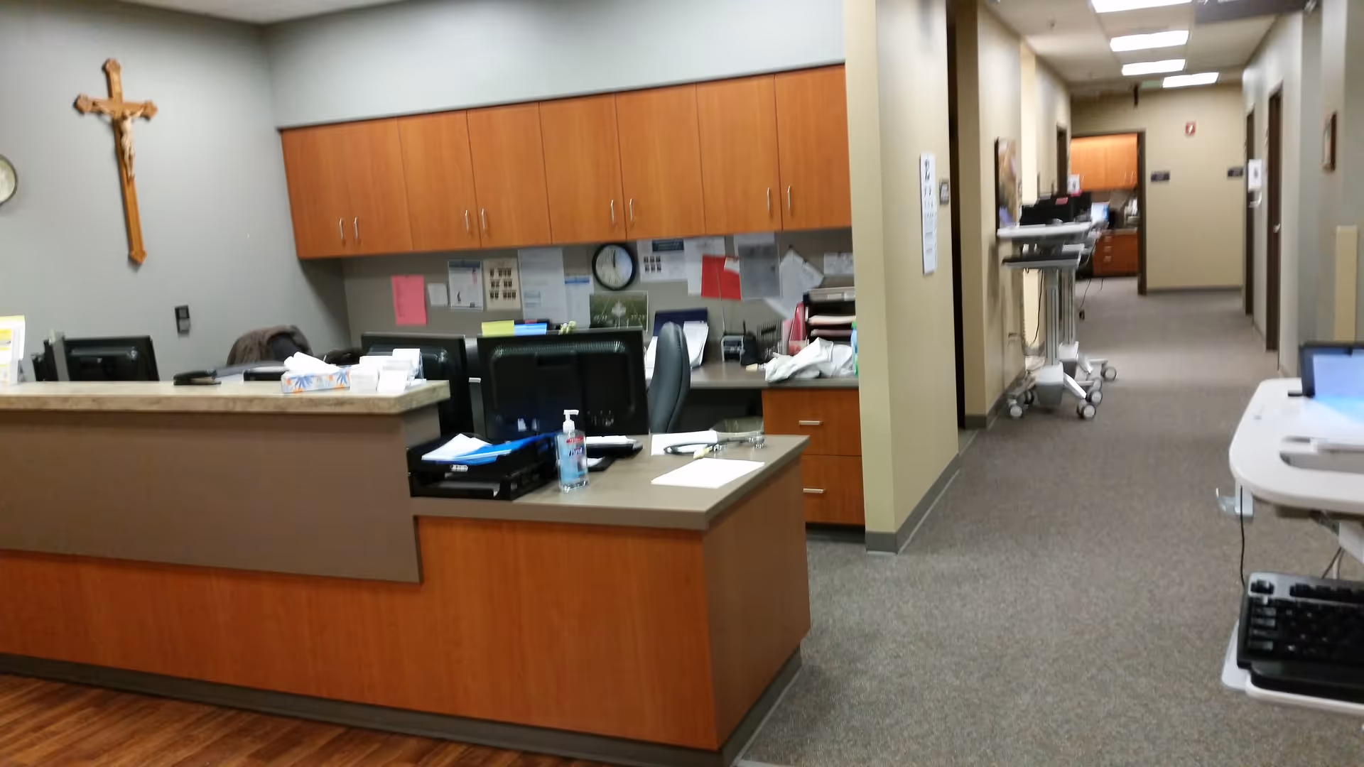 Reception desk with computers and cabinets in a hallway at St. Rose Health Center.