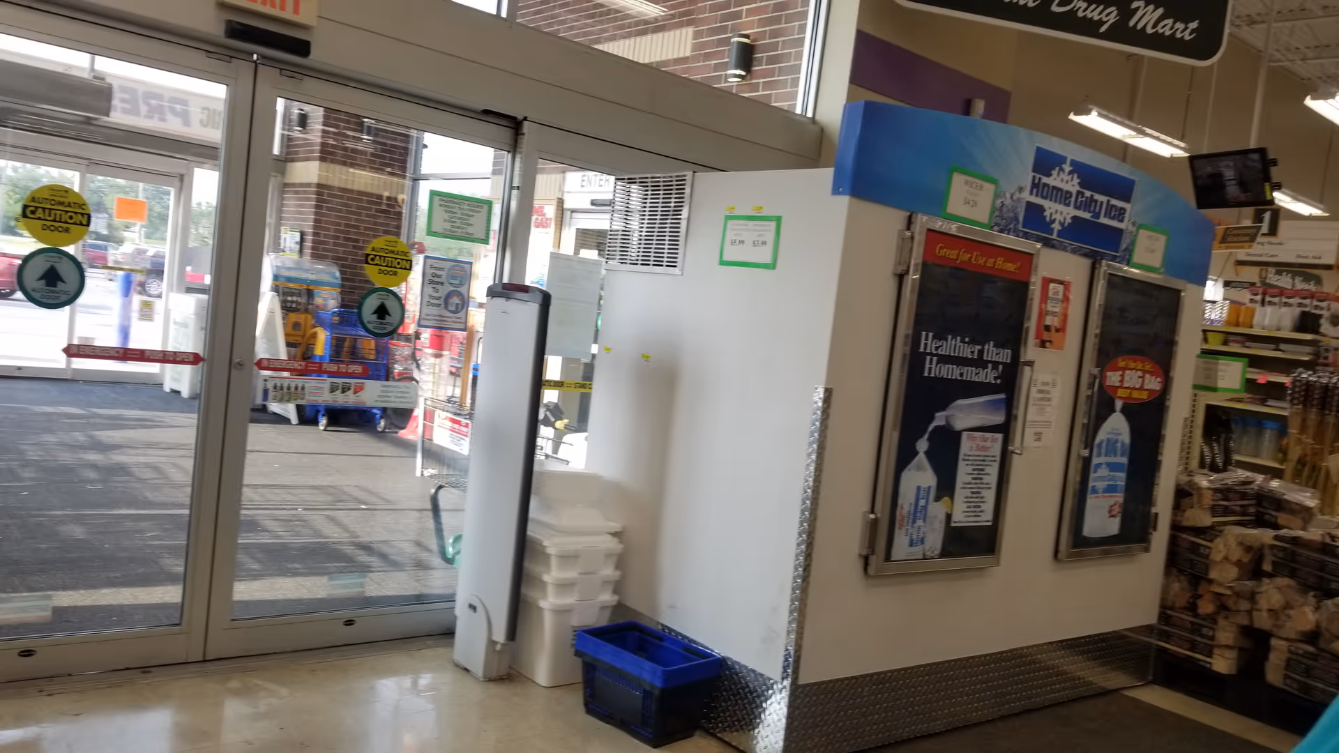 Inside Discount Drug Mart, glass entrance doors, vending machines, and fixtures visible.