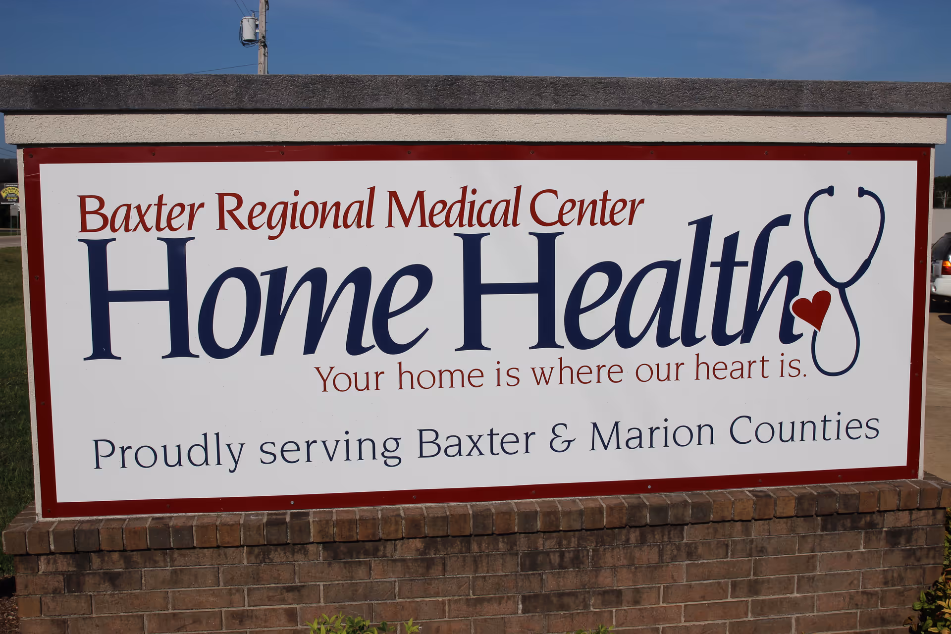 Exterior sign for Baxter Regional Medical Center Home Health with stethoscope logo.