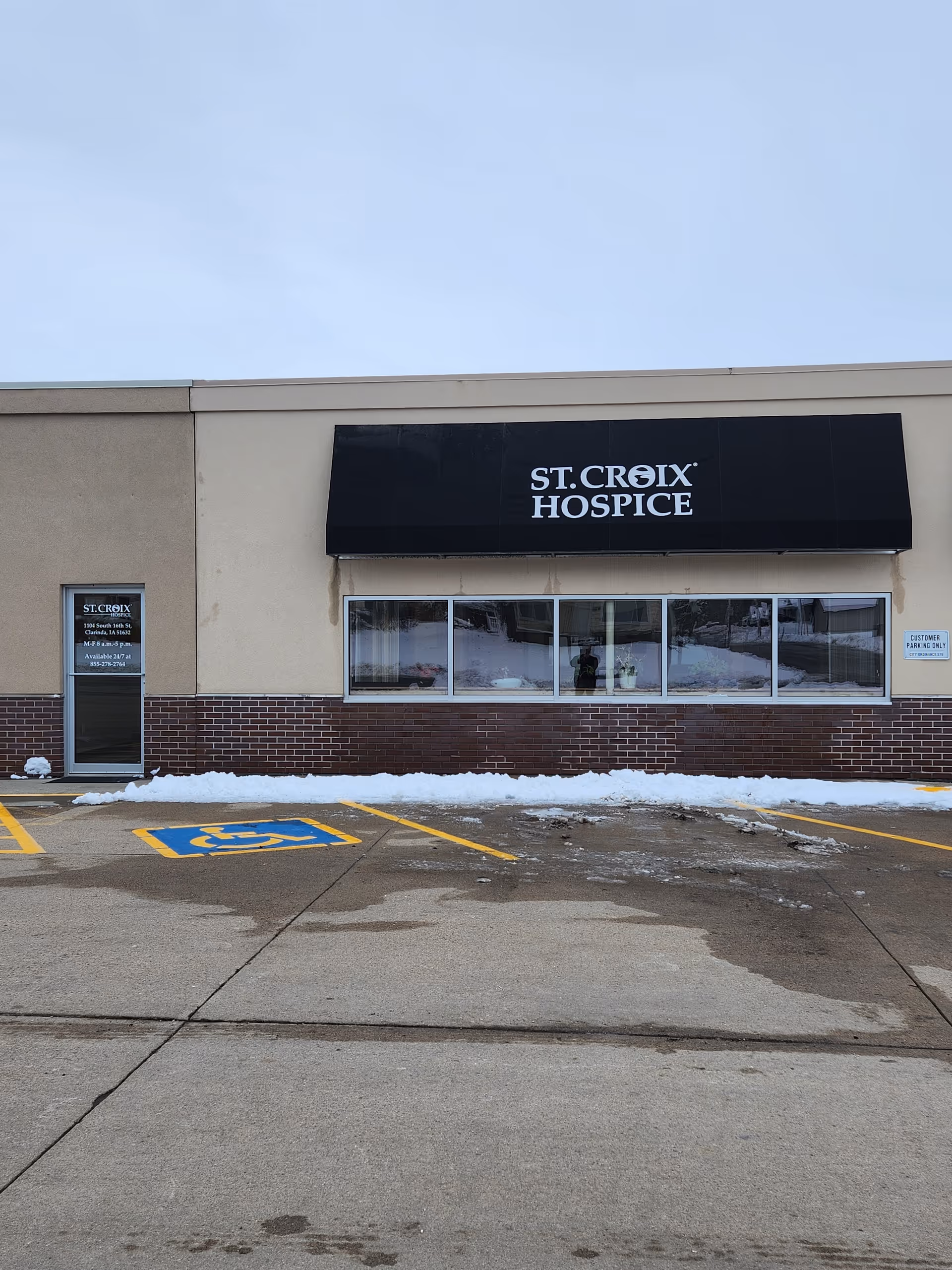 Exterior view of St. Croix Hospice front with sign and parking lot.