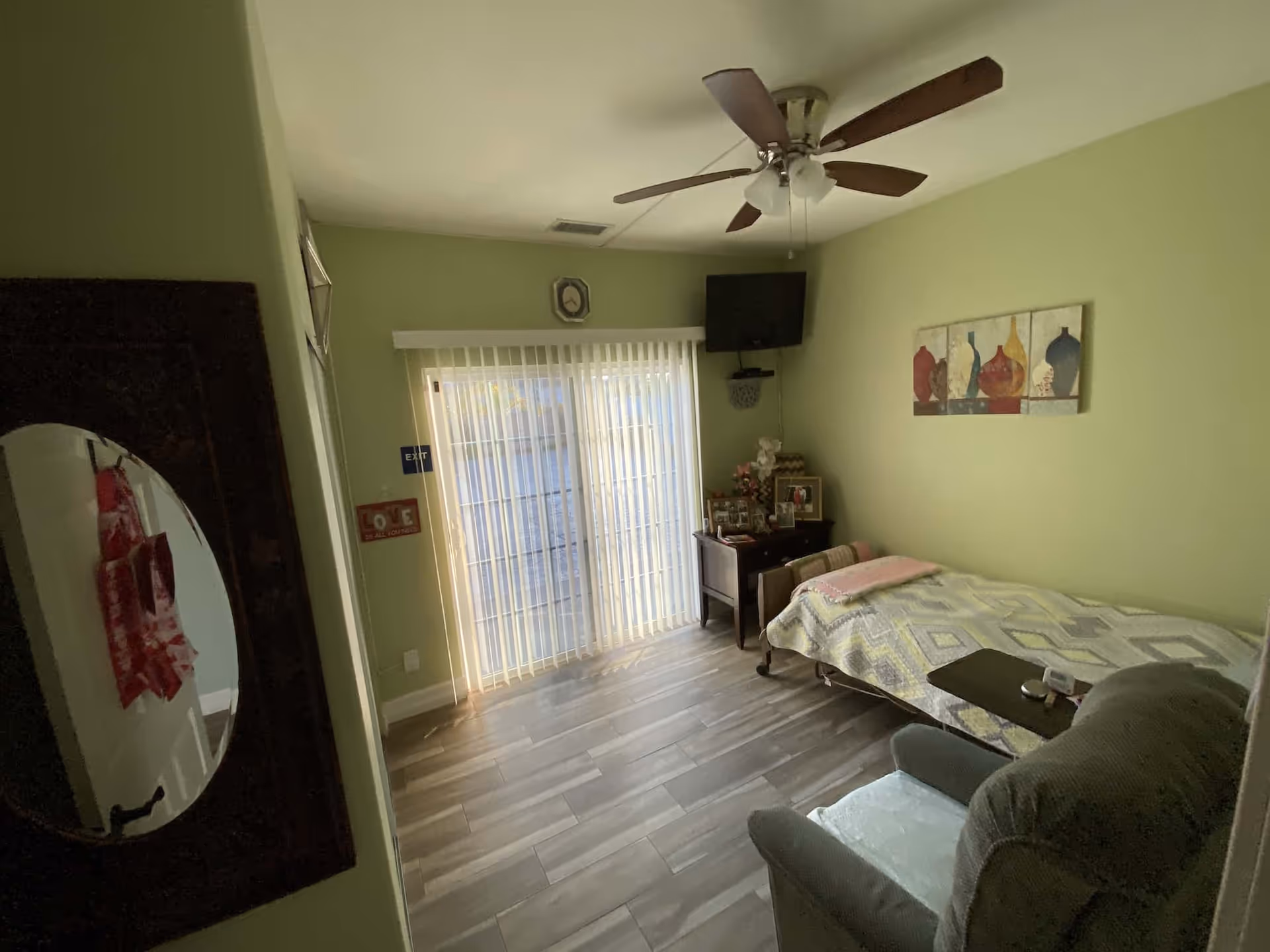Cozy Bianca's Home Care bedroom with bed, chair, dresser, and sliding glass doors.