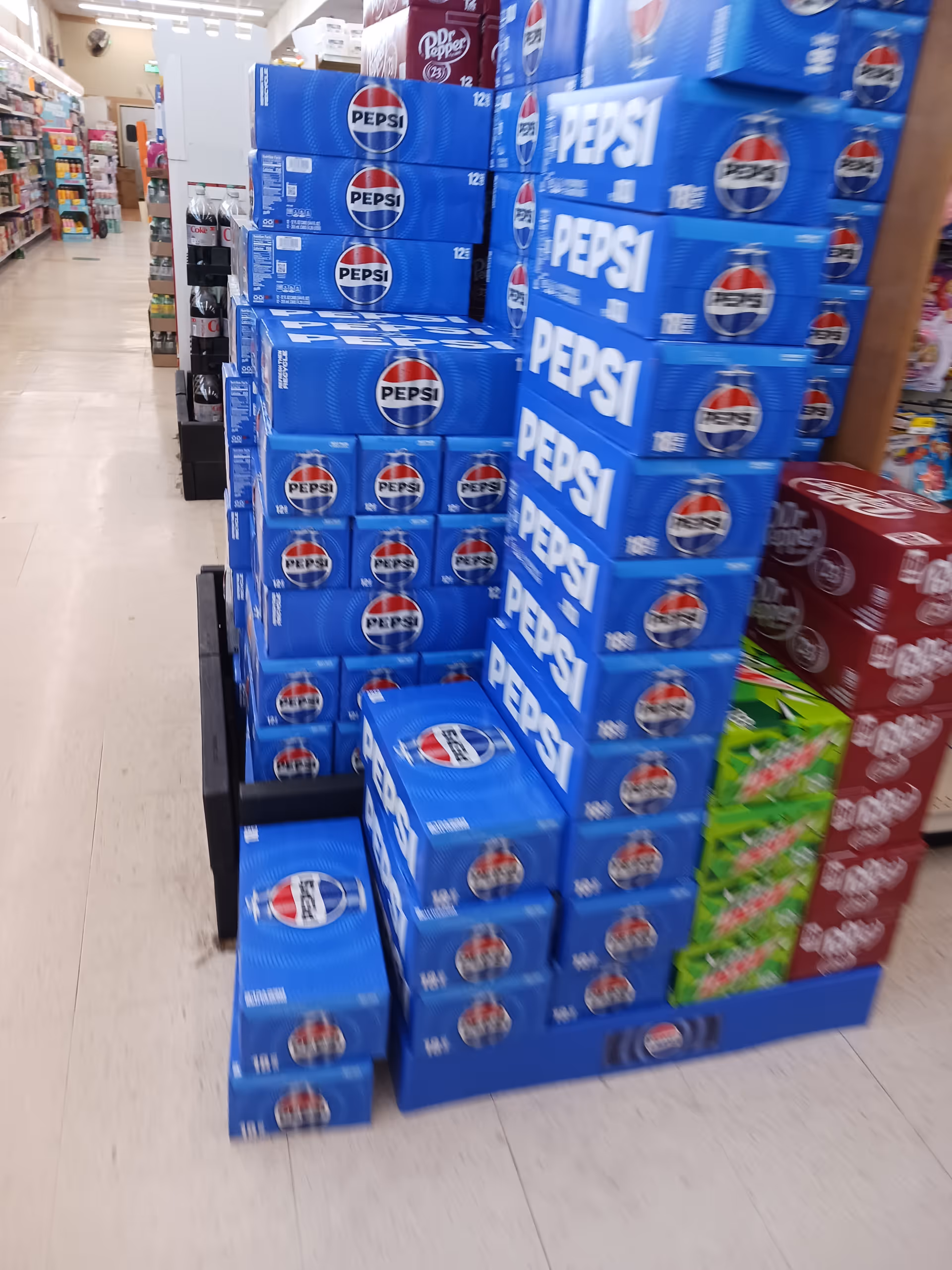 Tall stacks of blue Pepsi boxes fill a Discount Drug Mart store aisle.