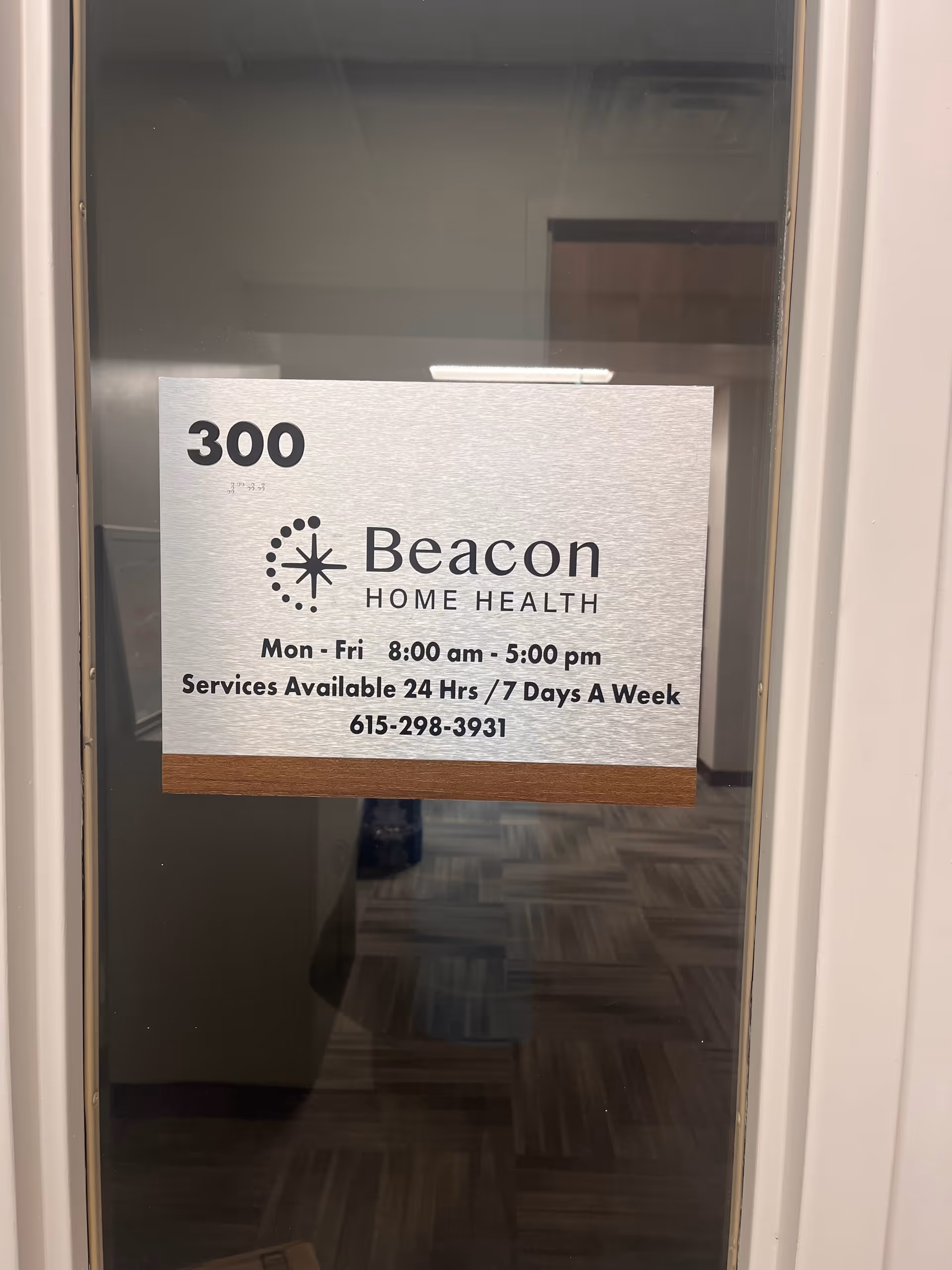 Door signage on a door for Beacon Home Health Care with hours and contact details.
