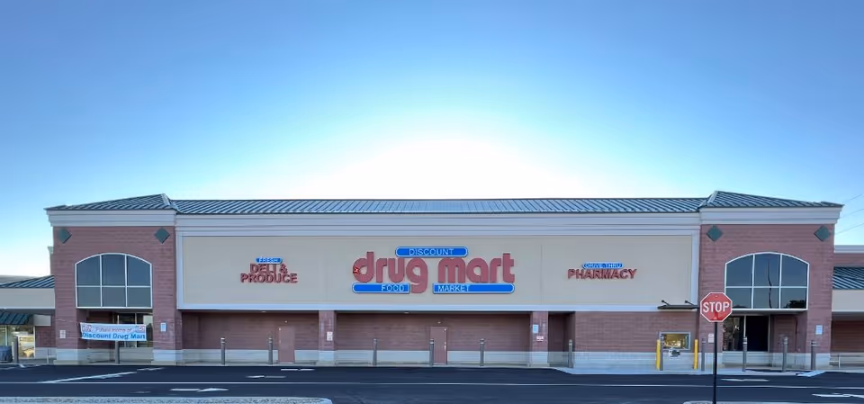 A single-story brick storefront with a large Discount Drug Mart sign and front parking.