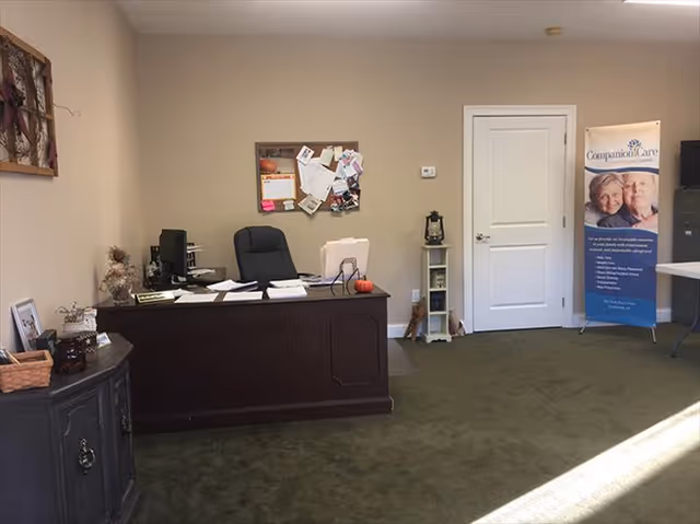 Reception area inside a Companion Care facility with desk, bulletin board, and banner.