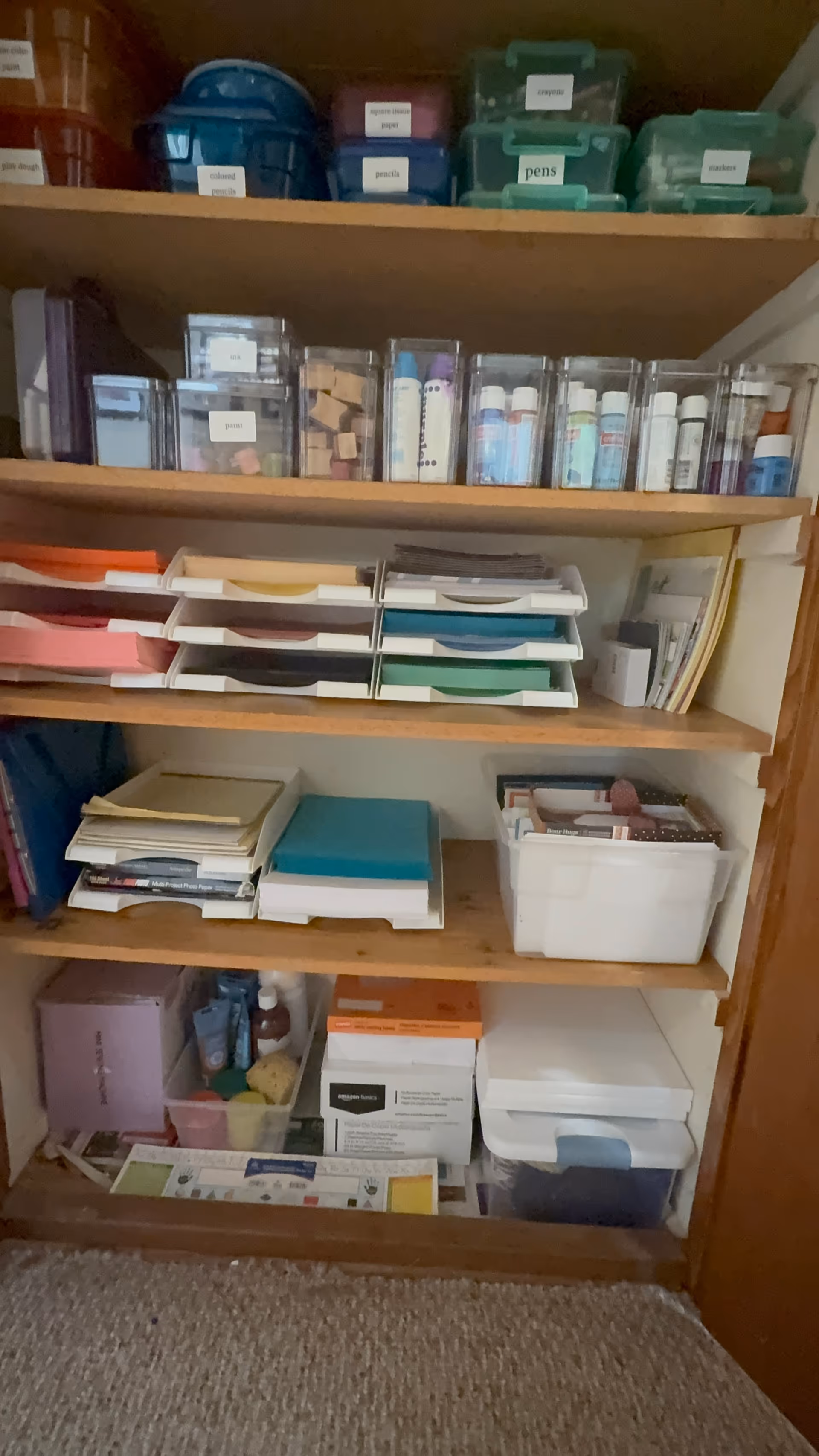 Shelves filled with labeled bins, organizers, and assorted office and craft supplies.