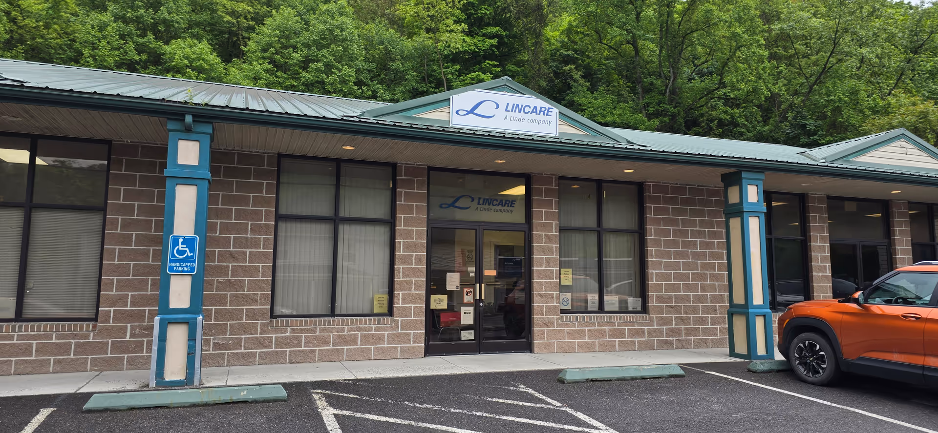 Brick exterior of LINCARE senior facility with a sign and handicap parking.
