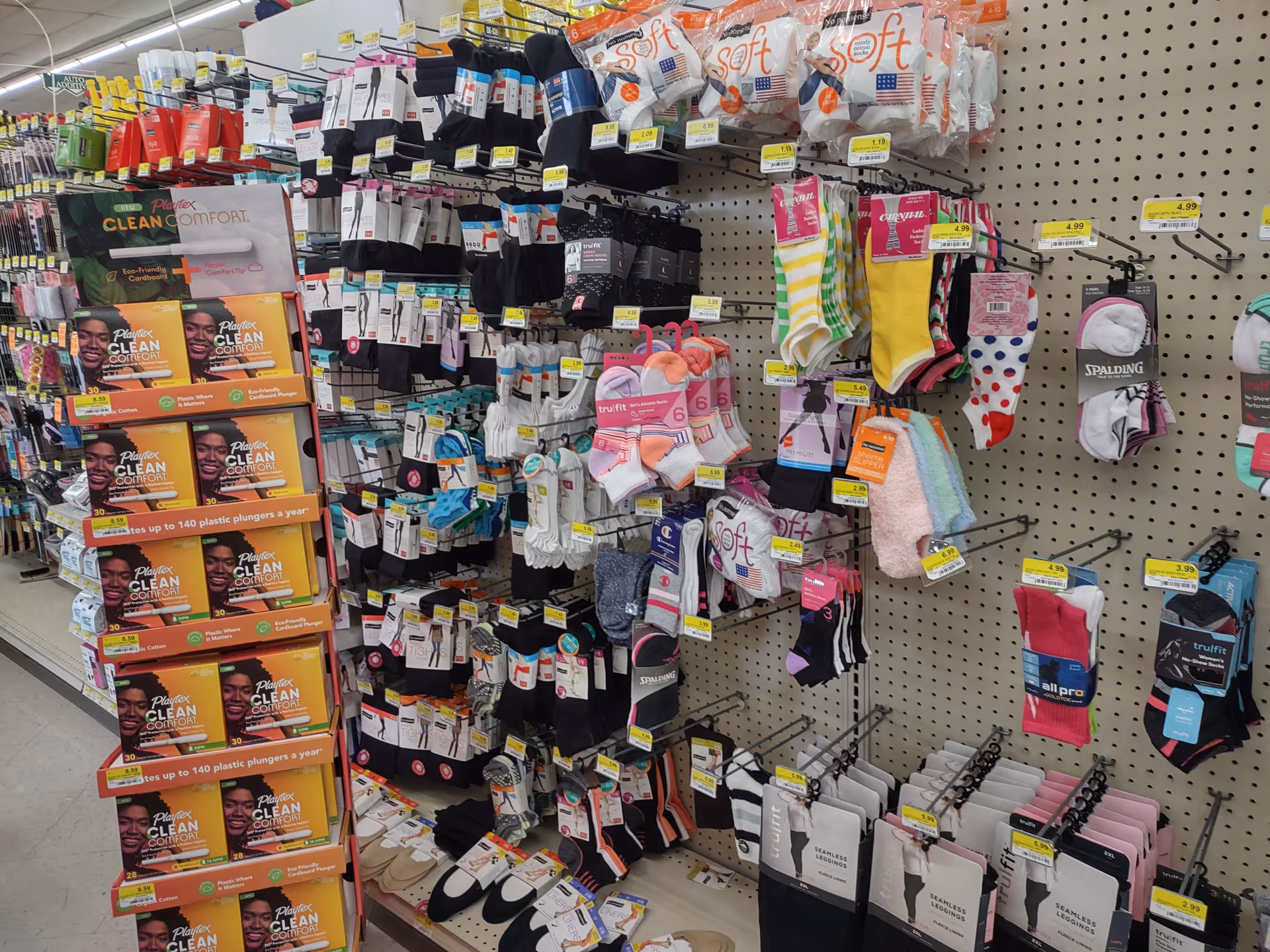 Store aisle with pegboard shelves displaying socks and foot care products.