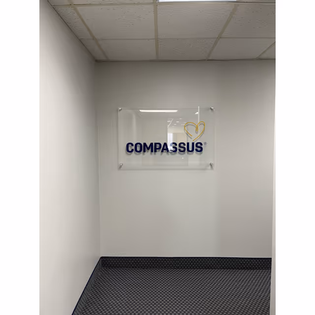 Interior hallway with a Compassus sign mounted on the wall.