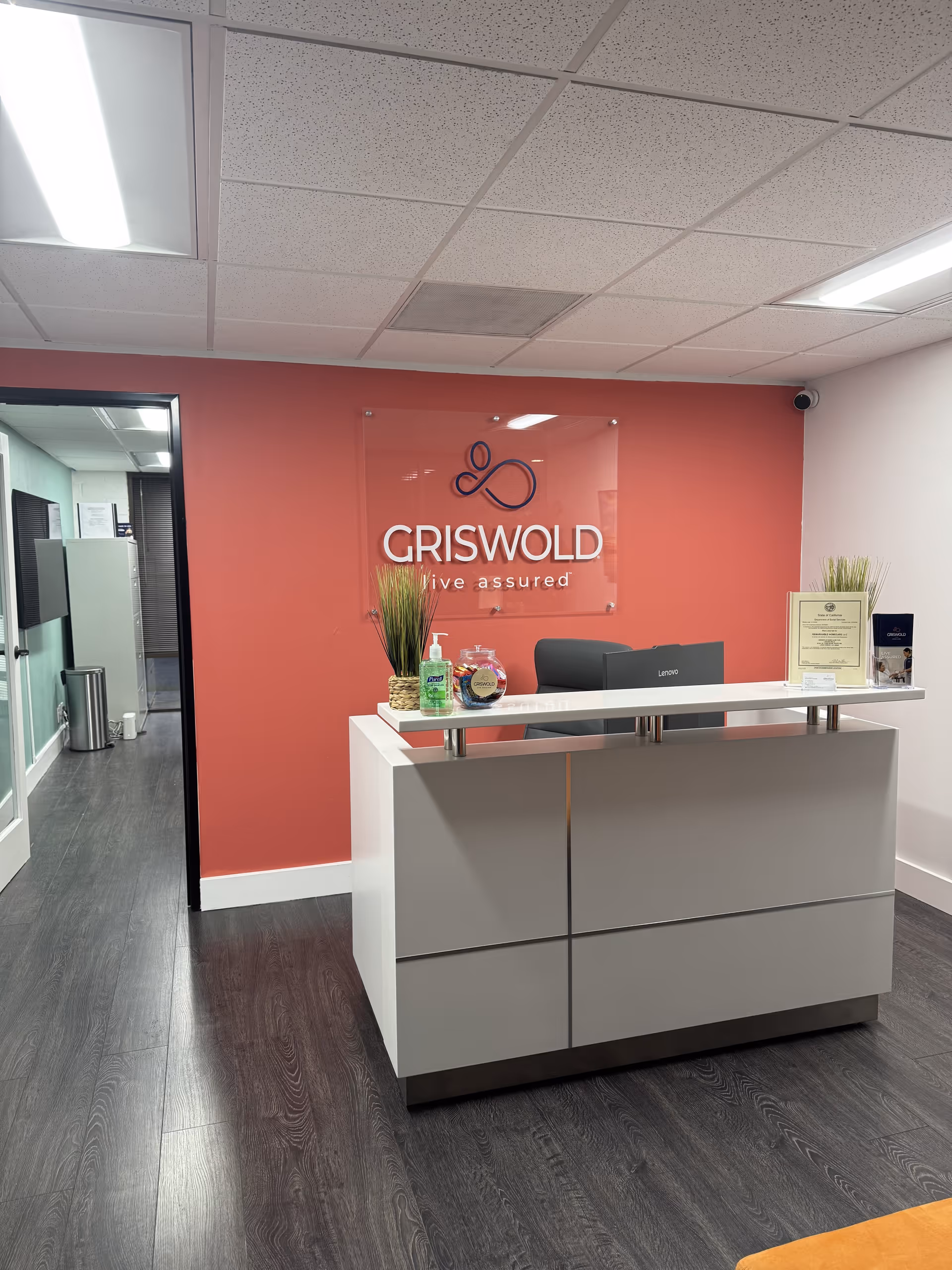 Reception desk in Griswold lobby with coral wall and modern gray cabinetry.