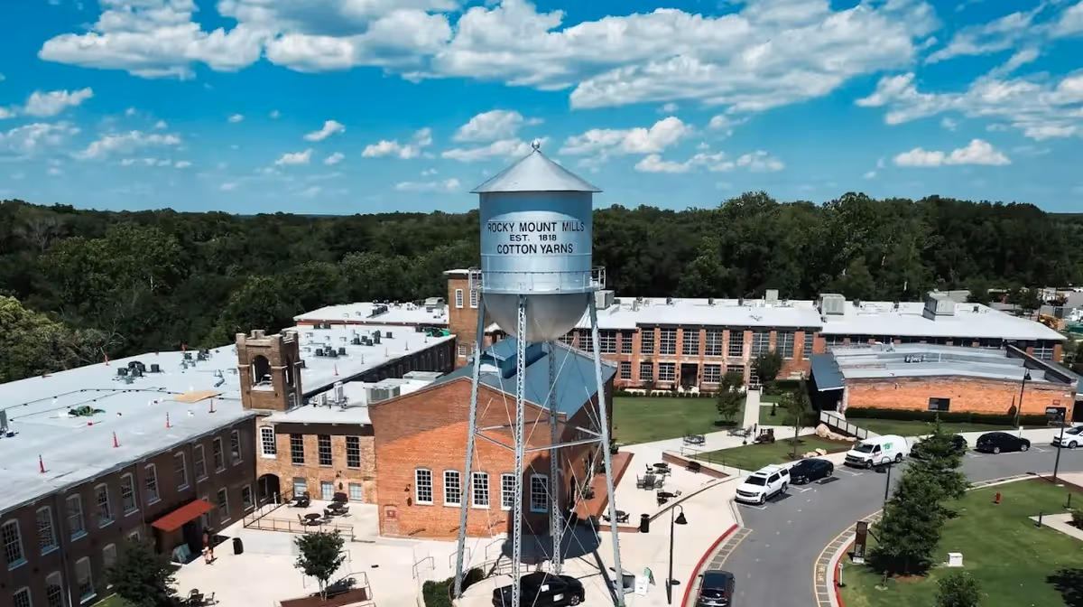 Aerial view of a brick senior living campus with a tall water tower and greenery.