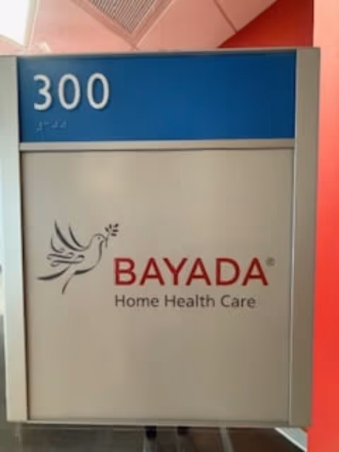 Blue BAYADA sign with room 300 in an interior hallway of the facility.