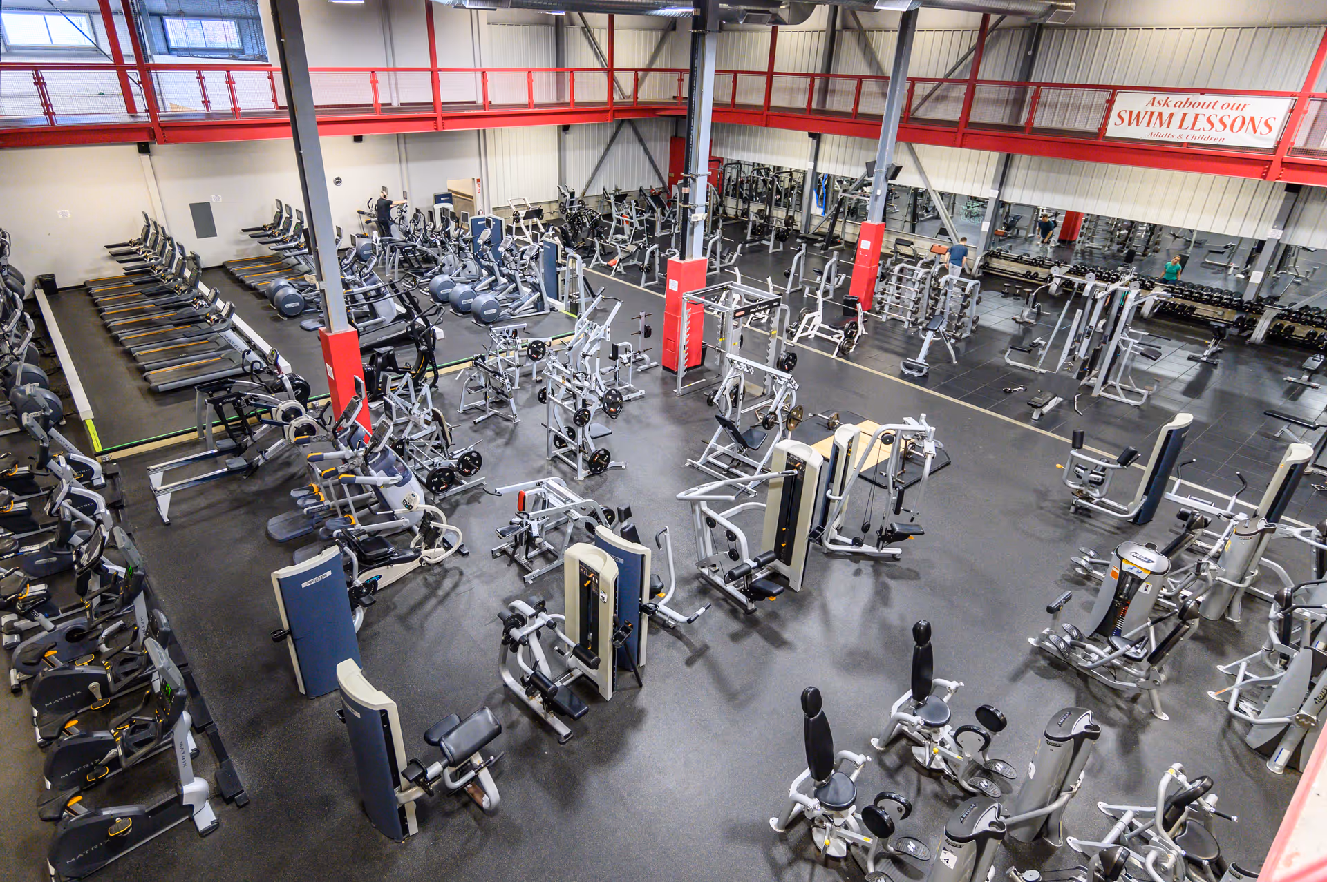 Large indoor gym filled with weight machines and cardio equipment.