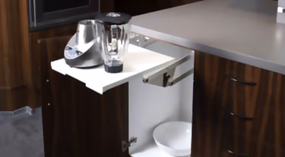 Kitchen island with pull-out shelf, blender, and kettle on a wood cabinet.