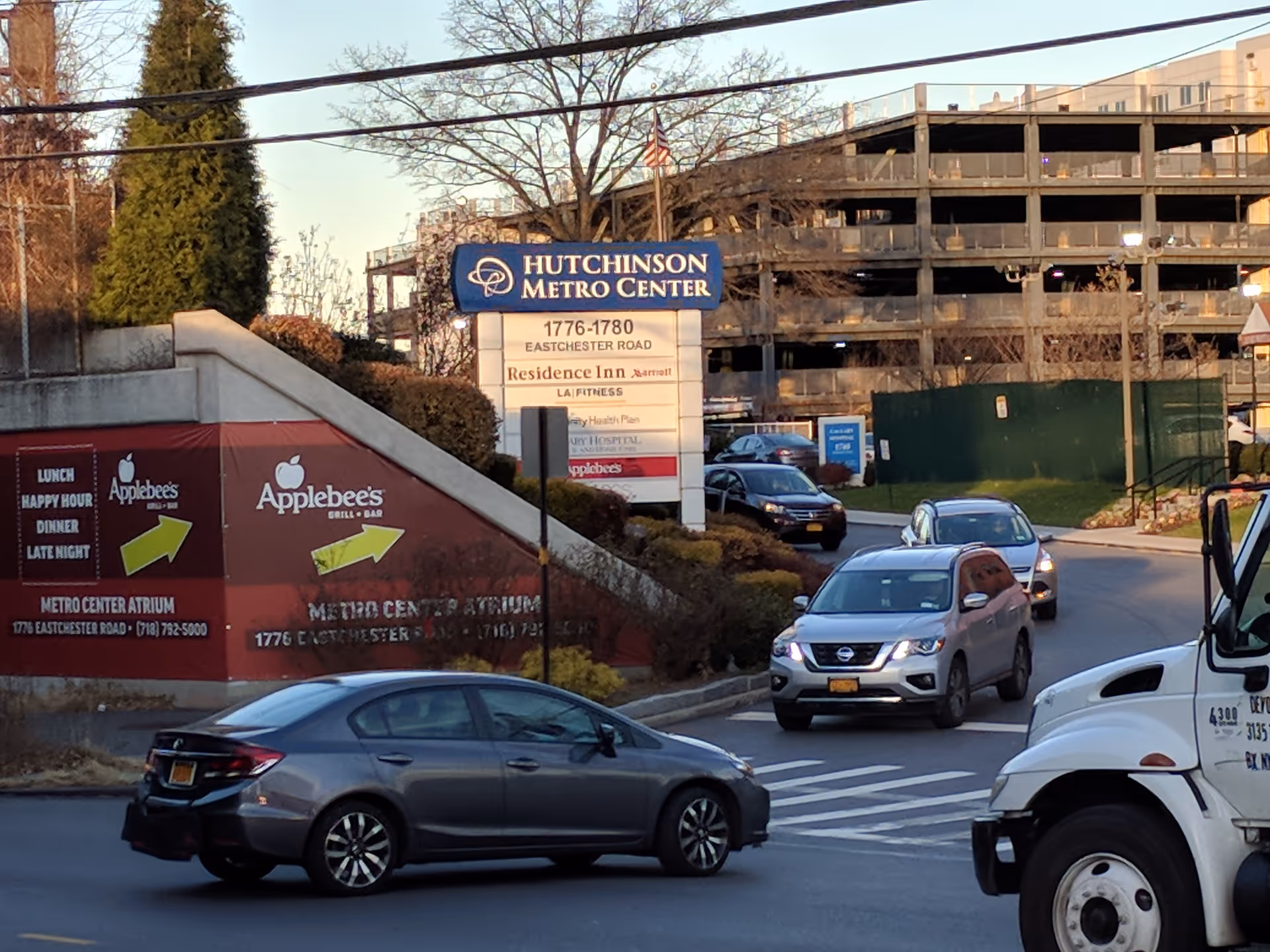 A busy urban street scene with a sign for Hutchinson Metro Center and construction in background.