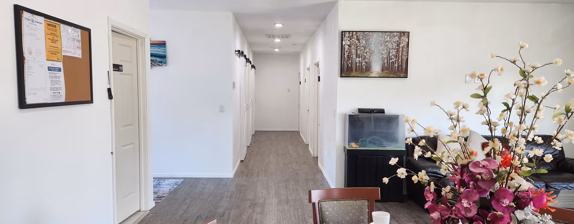 Bright interior hallway of a senior living facility with multiple doors.