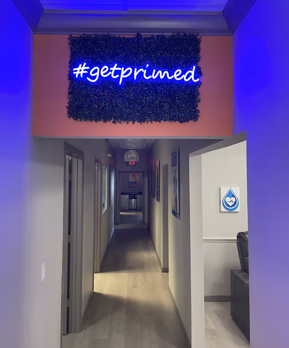 Interior hallway at Prime IV Hydration & Wellness with neon '#getprimed' sign.