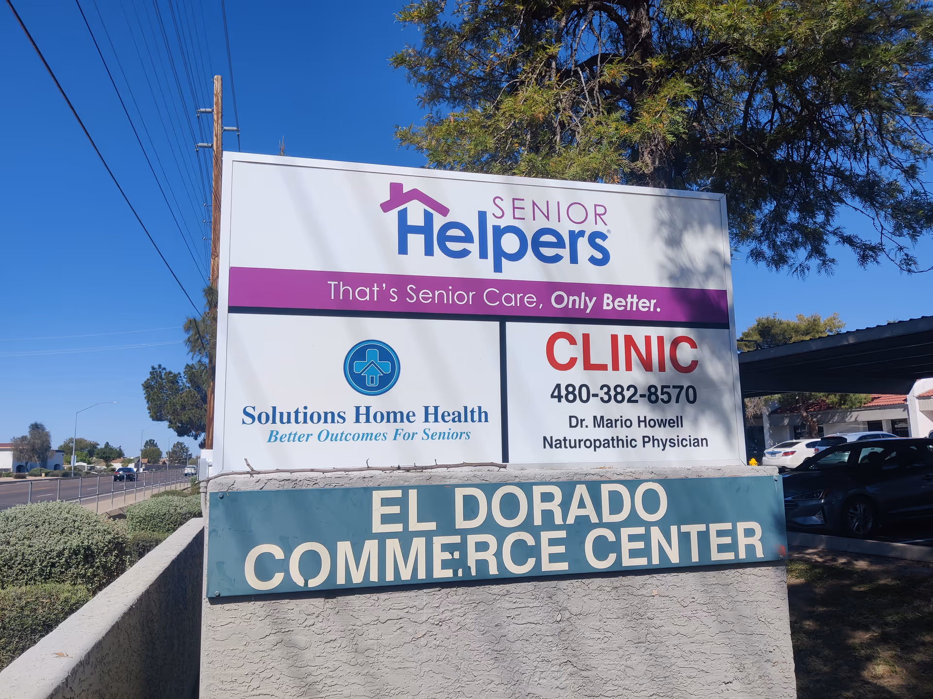 Outdoor signboard advertising Senior Helpers and El Dorado Commerce Center at street corner.