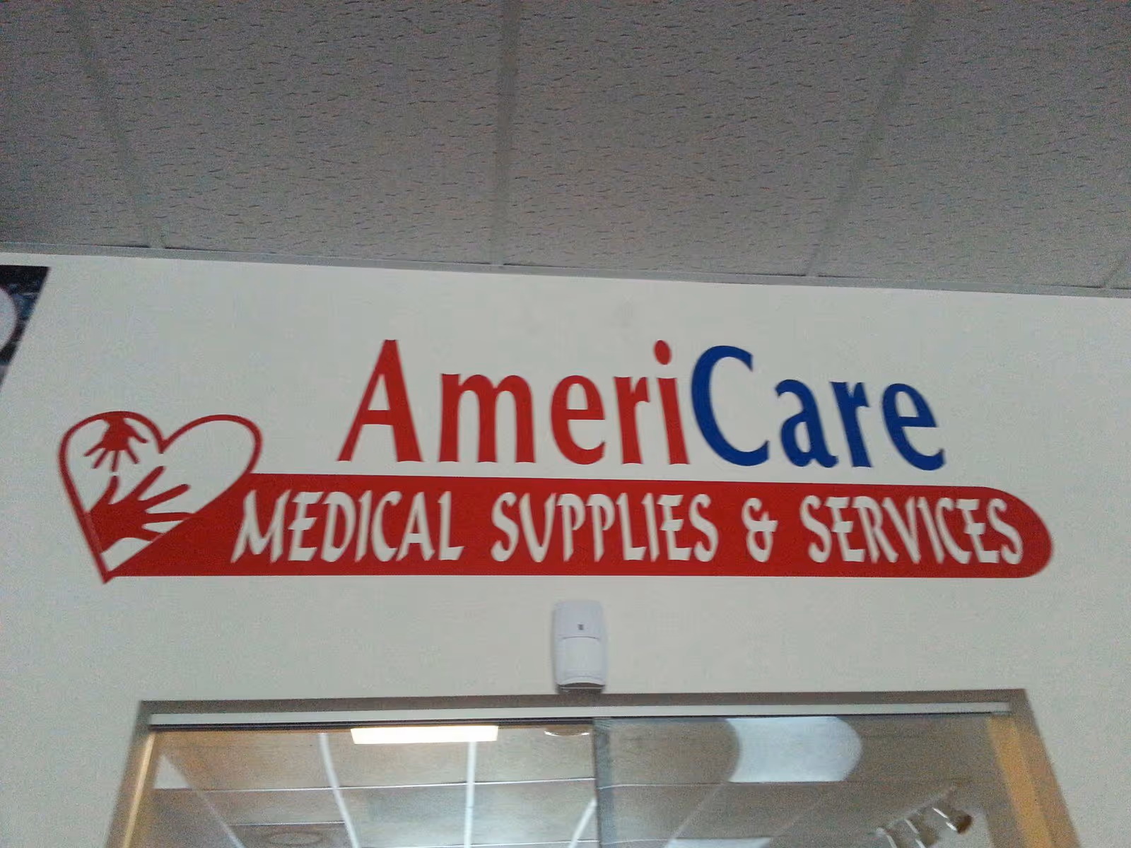 Interior wall sign reading AmeriCare Medical Supplies and Services above a doorway.
