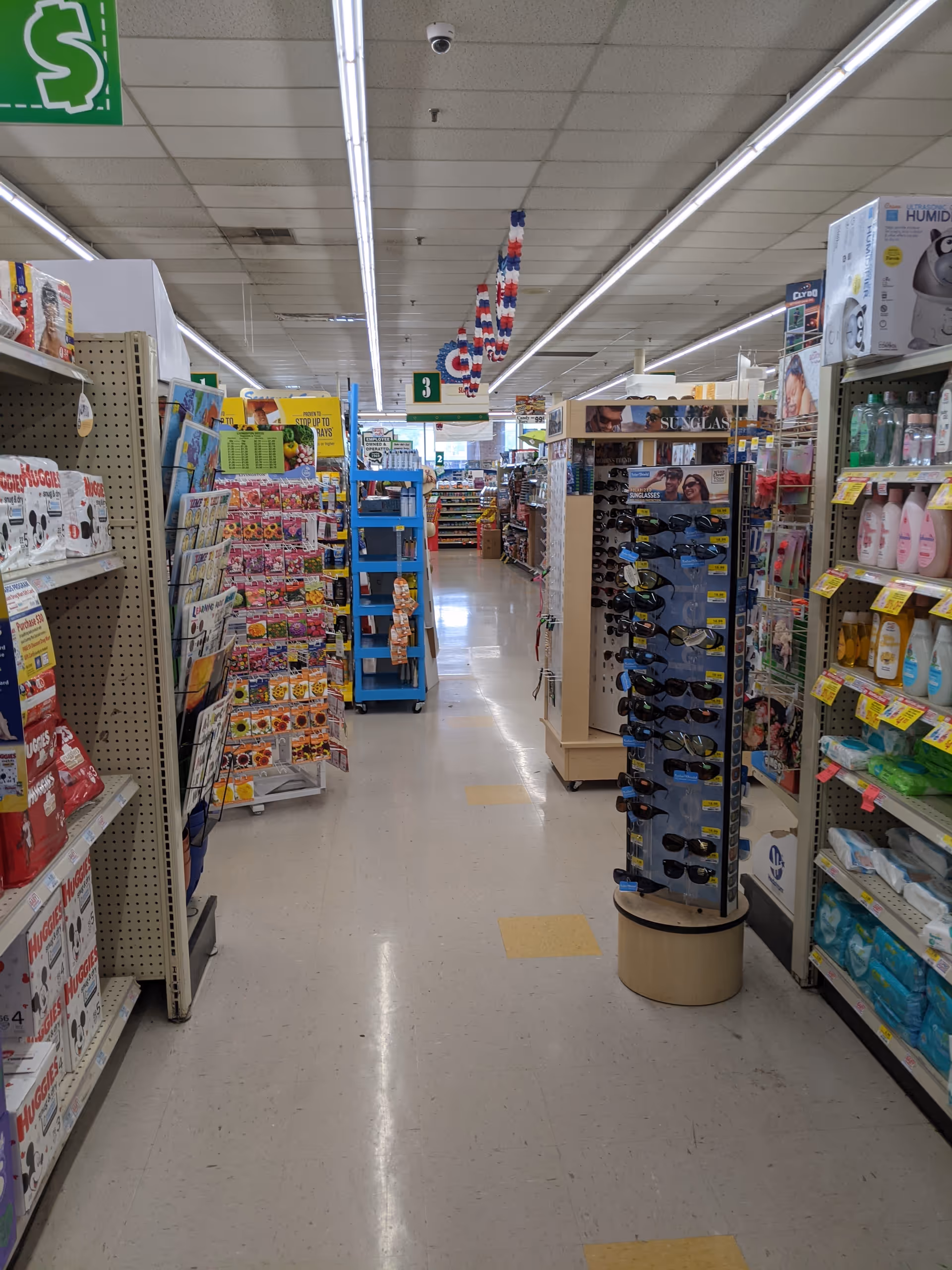 Inside Discount Drug Mart, a bright aisle with shelves full of products and signage.