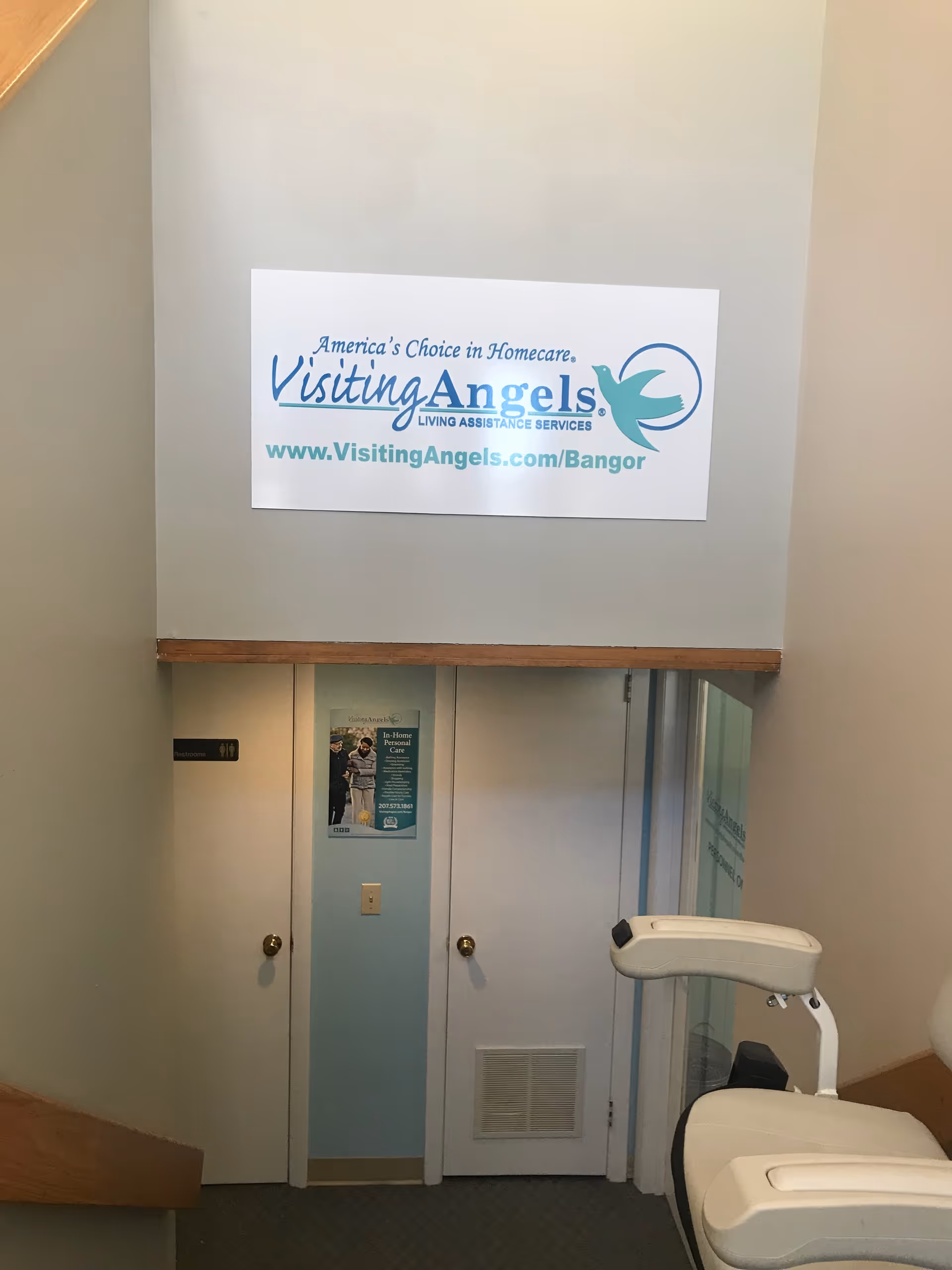 Interior hallway with a large Visiting Angels sign mounted on the wall.