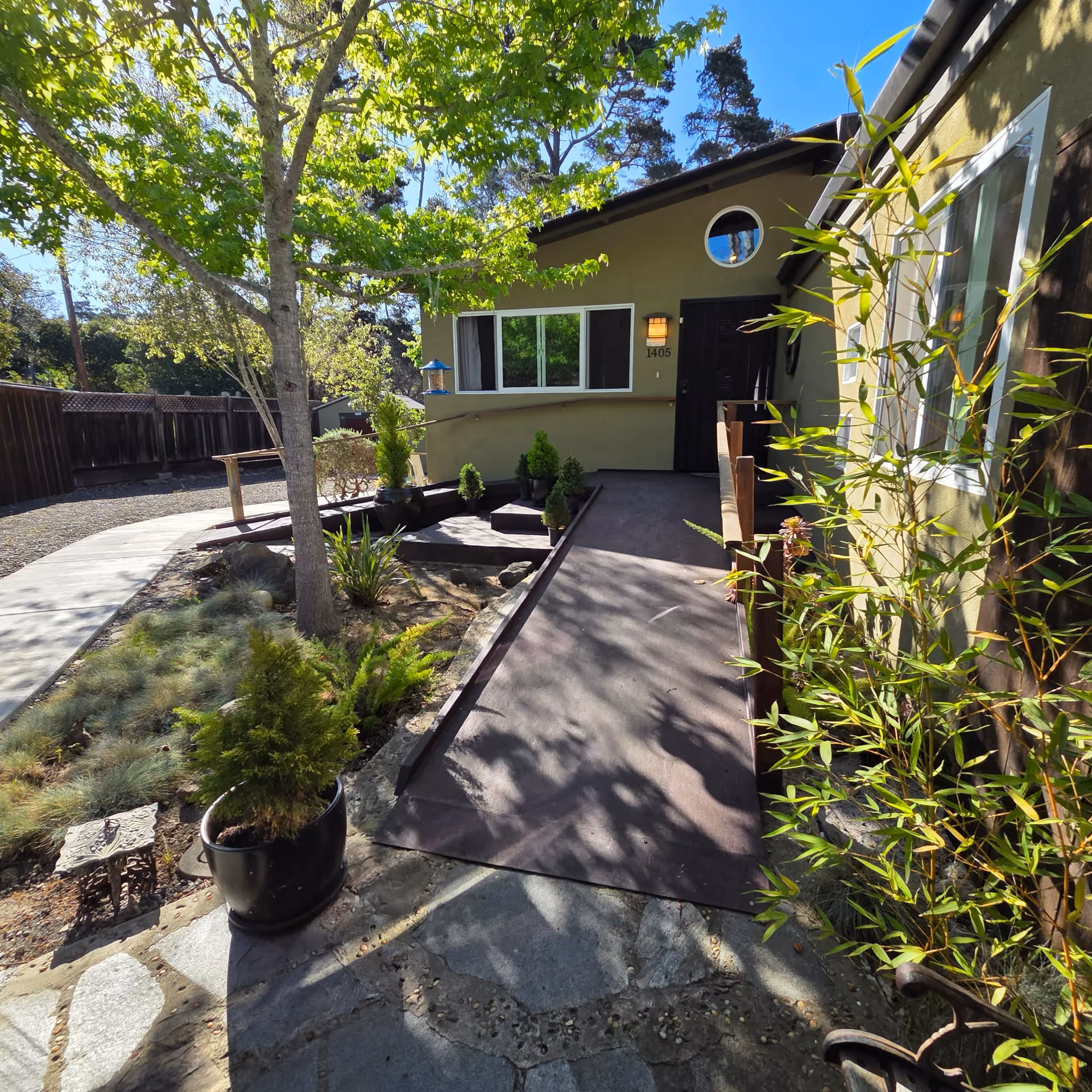 Exterior view of Cherish Care front entrance with ramp, pathway, and greenery.