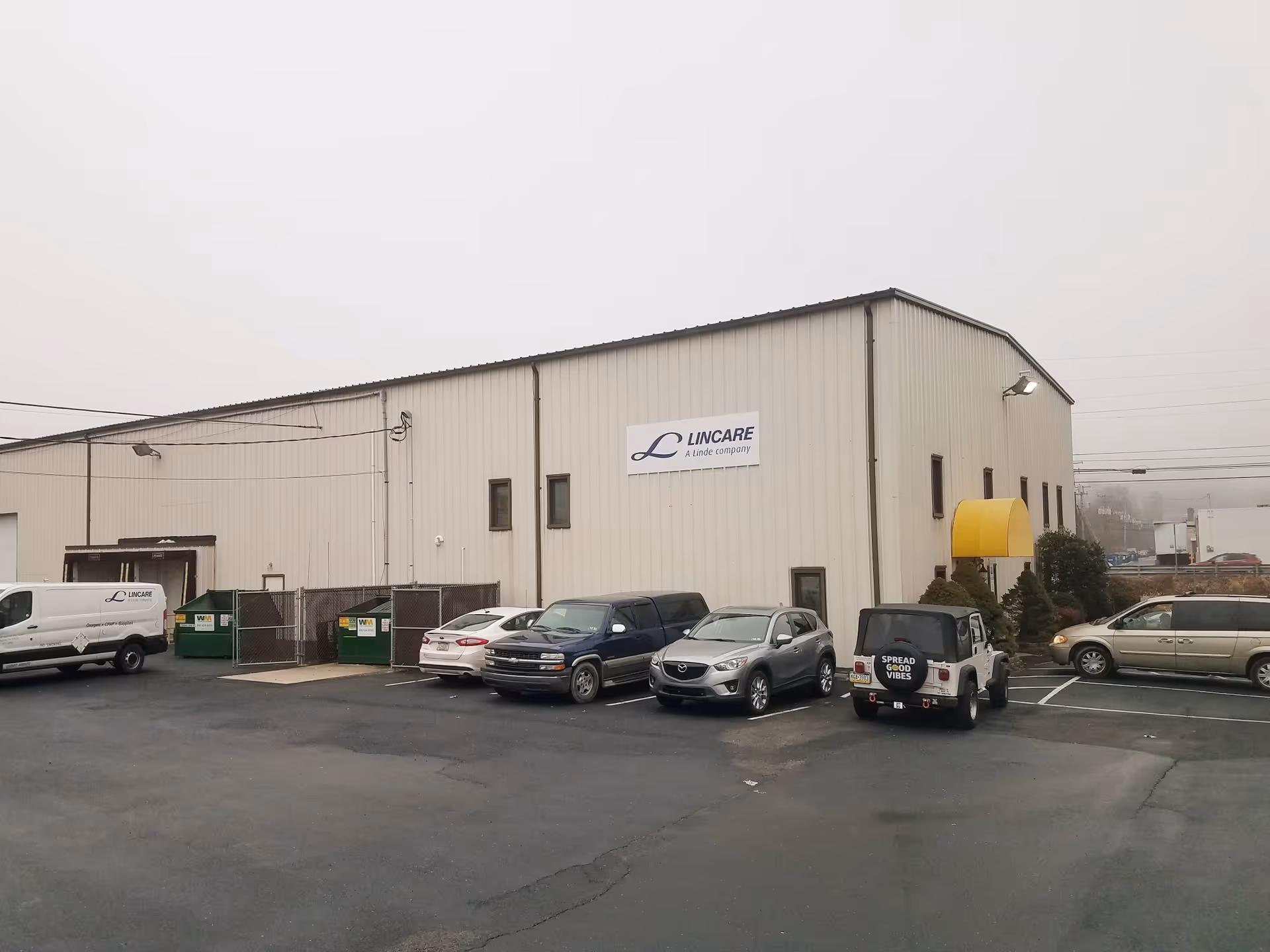 Exterior view of a Lincare facility with a parking lot and several vehicles.