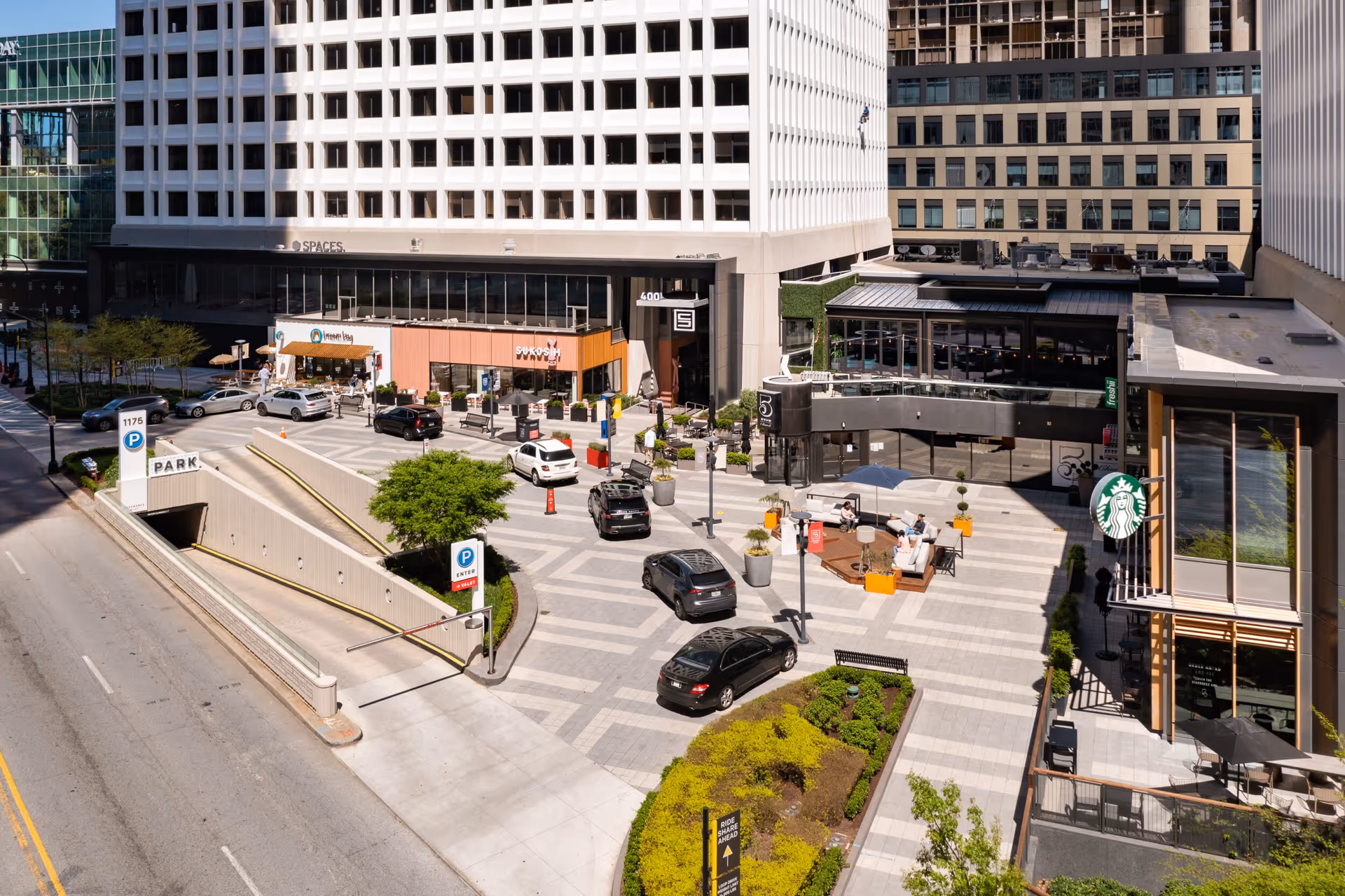 Urban building complex with outdoor seating and a pedestrian plaza.