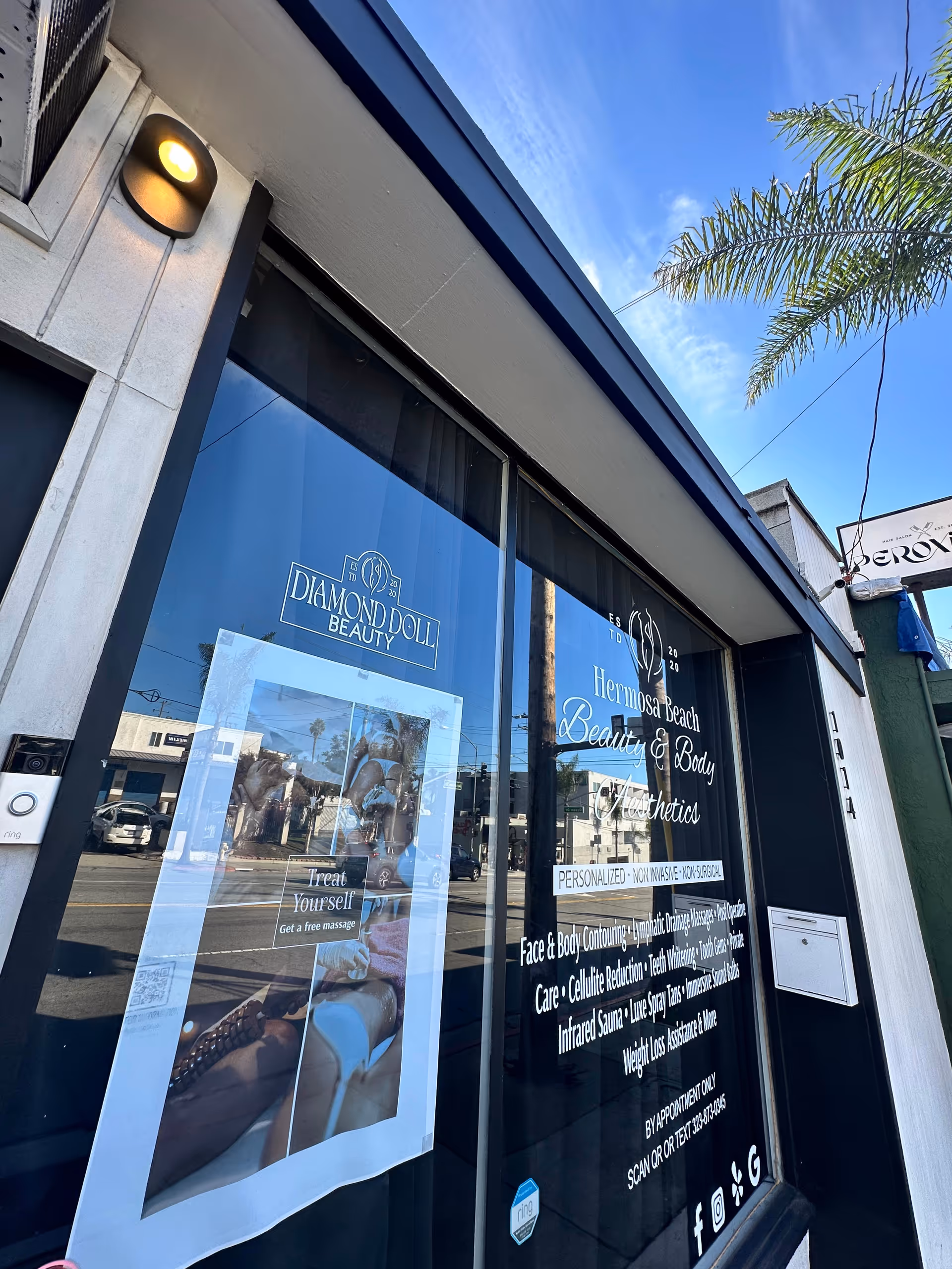 Exterior of Diamond Doll Beauty and Body storefront with glass windows and signage.
